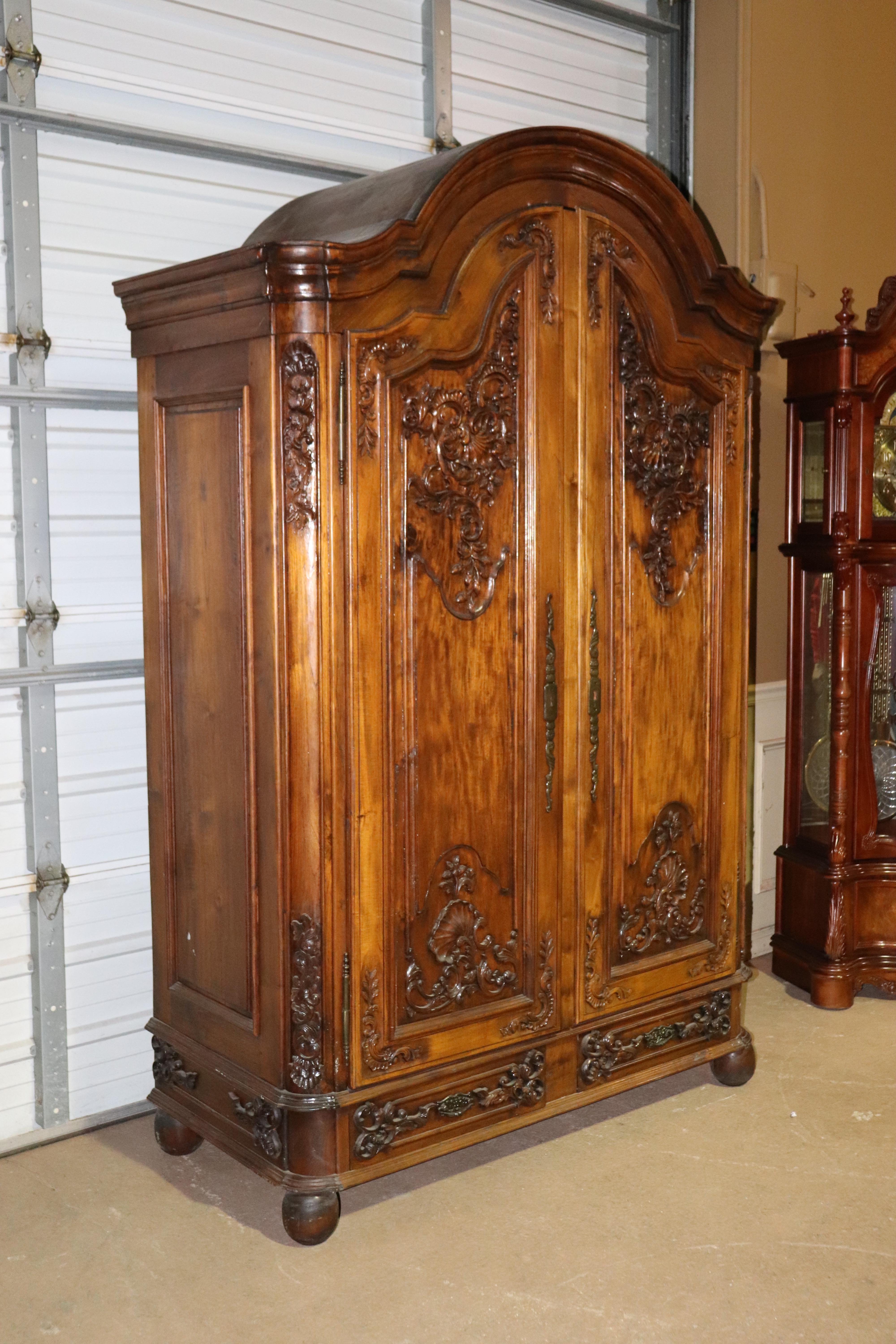 This is a custom made hand carved solid walnut armoire. Designed in the French country tradition this piece is designed to come apart and can be installed in any home, or apartment. It breaks down completely. The armoire is not very old, less than
