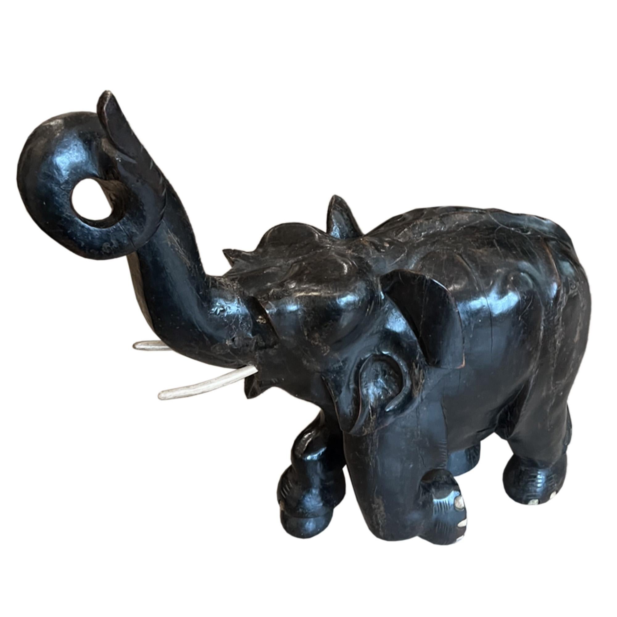 Dieser fröhliche Elefant wurde in den 1950er Jahren in Ceylon aus ebonisiertem Padauk-Holz geschnitzt. 

Bitte schauen Sie sich alle Bilder an, um die Details dieses großen dekorativen Stücks zu sehen, so schön Ausdruck und Detail. 

Eine großartige