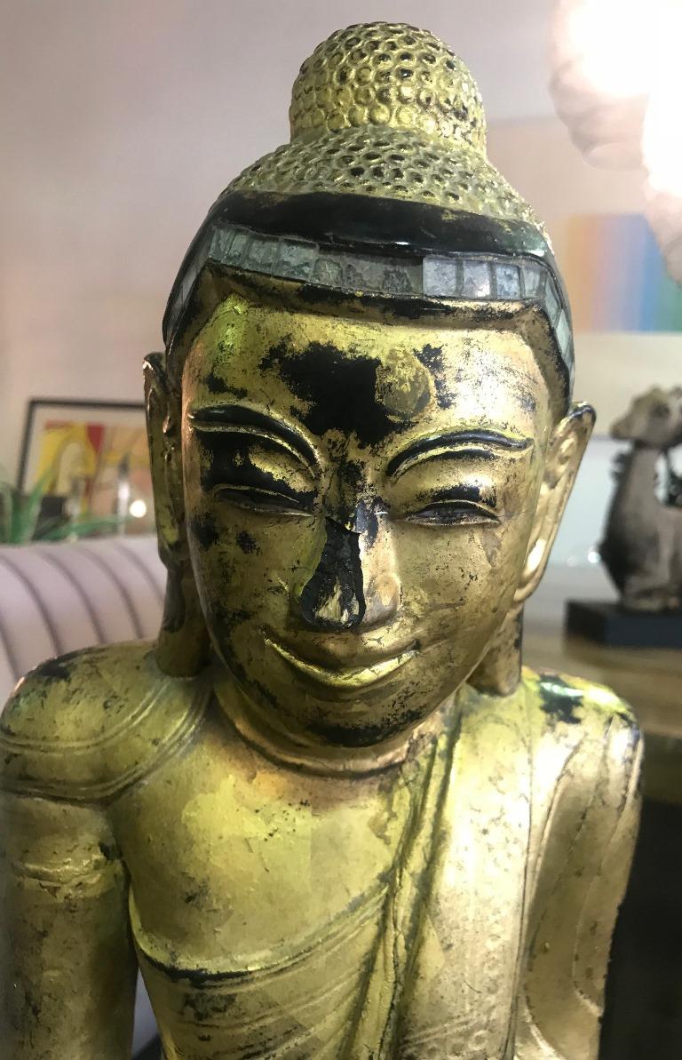 Amazing piece. Heavy and solid. Carved from a single block of wood and wonderfully colored and decorated. Buddha has a serene facial expression with hands in the 