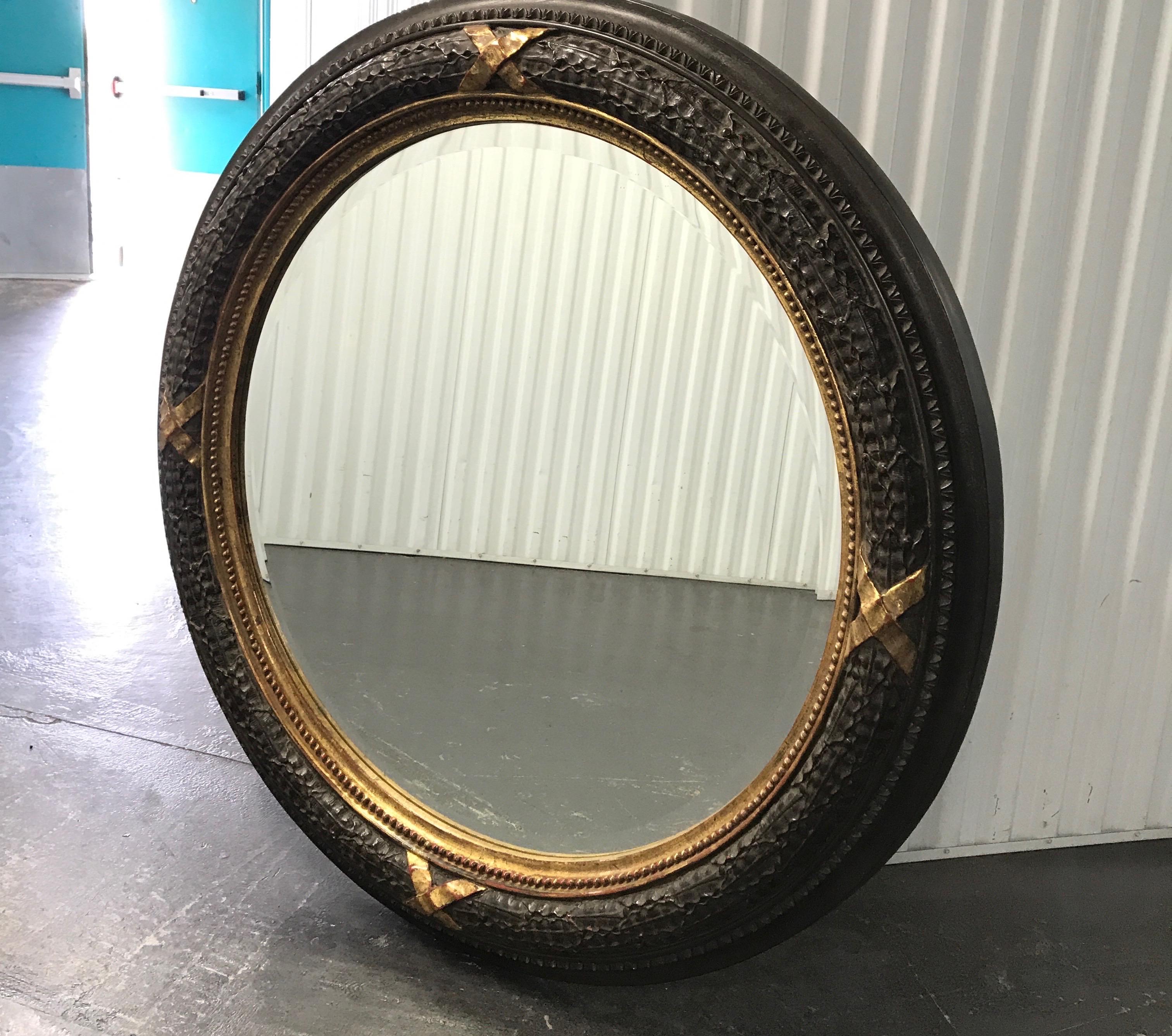 Large carved neoclassical style wood mirror with gilded trim and accents.