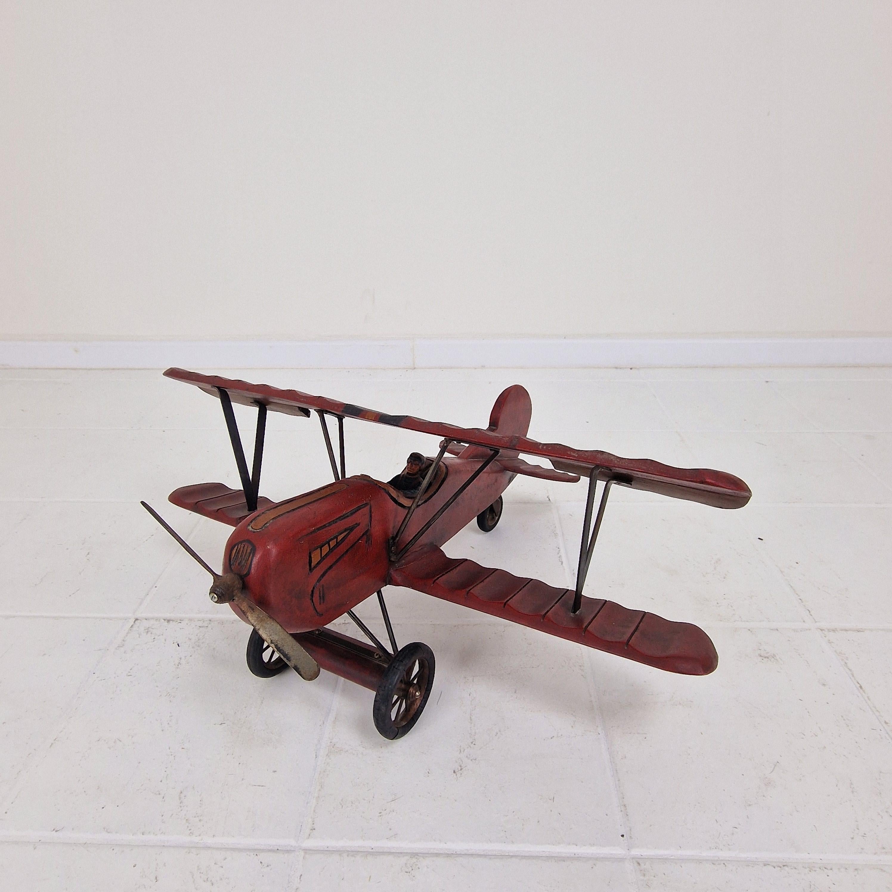 Bellissimo modello di biplano vintage in legno.
L'aereo è costruito come l'originale con un pilota, ruote in gomma e un'elica in metallo.

Una bella aggiunta a uno scaffale, a una console o alla stanza dei bambini. anche per gli appassionati di