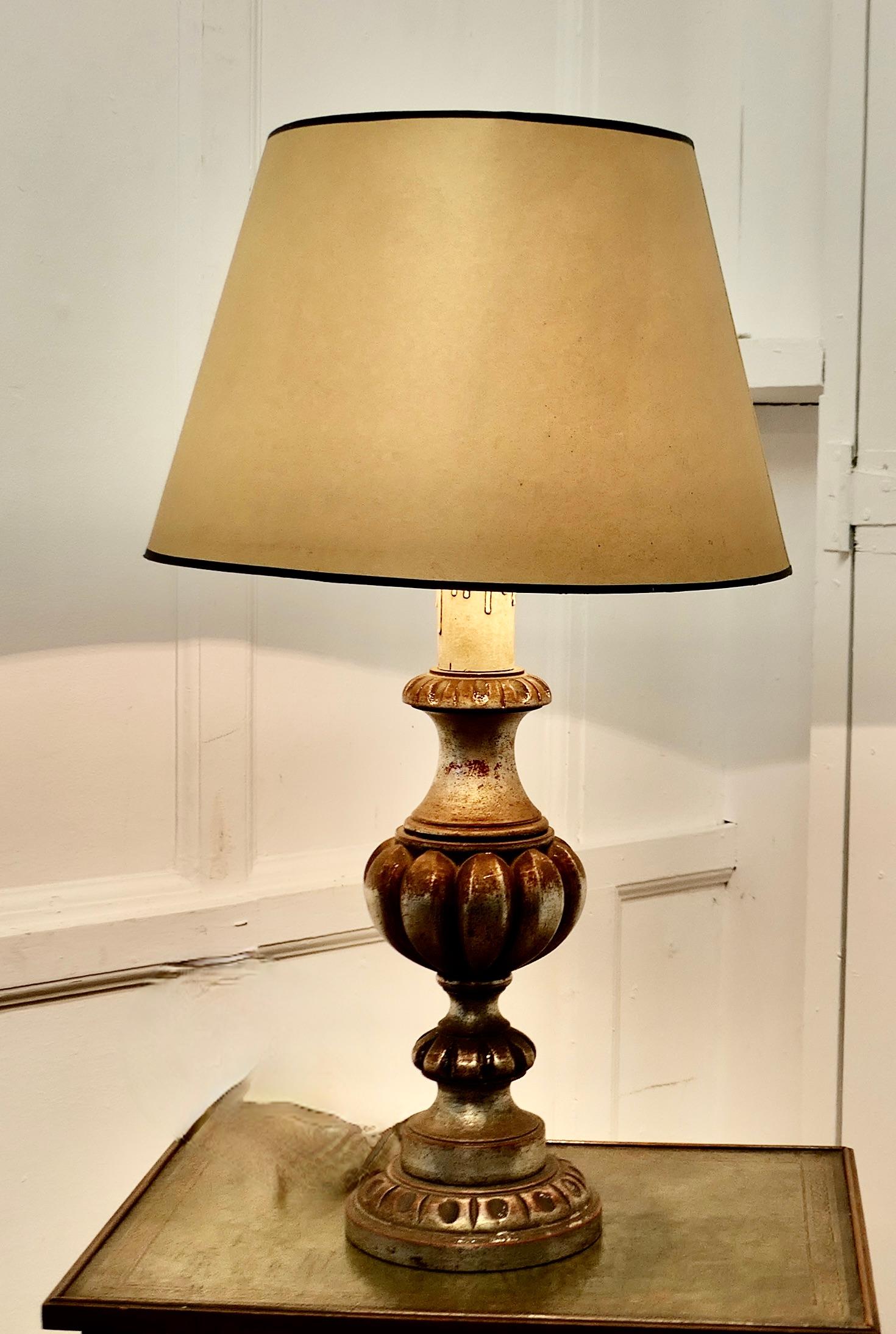 Large Carved Wooden Table Lamp

This is a great statement piece, it has a large carved base which has been finished to look like distressed tarnished silver
It comes with an oversize parchment shade, the wiring is in good condition
The Lamp is 31”
