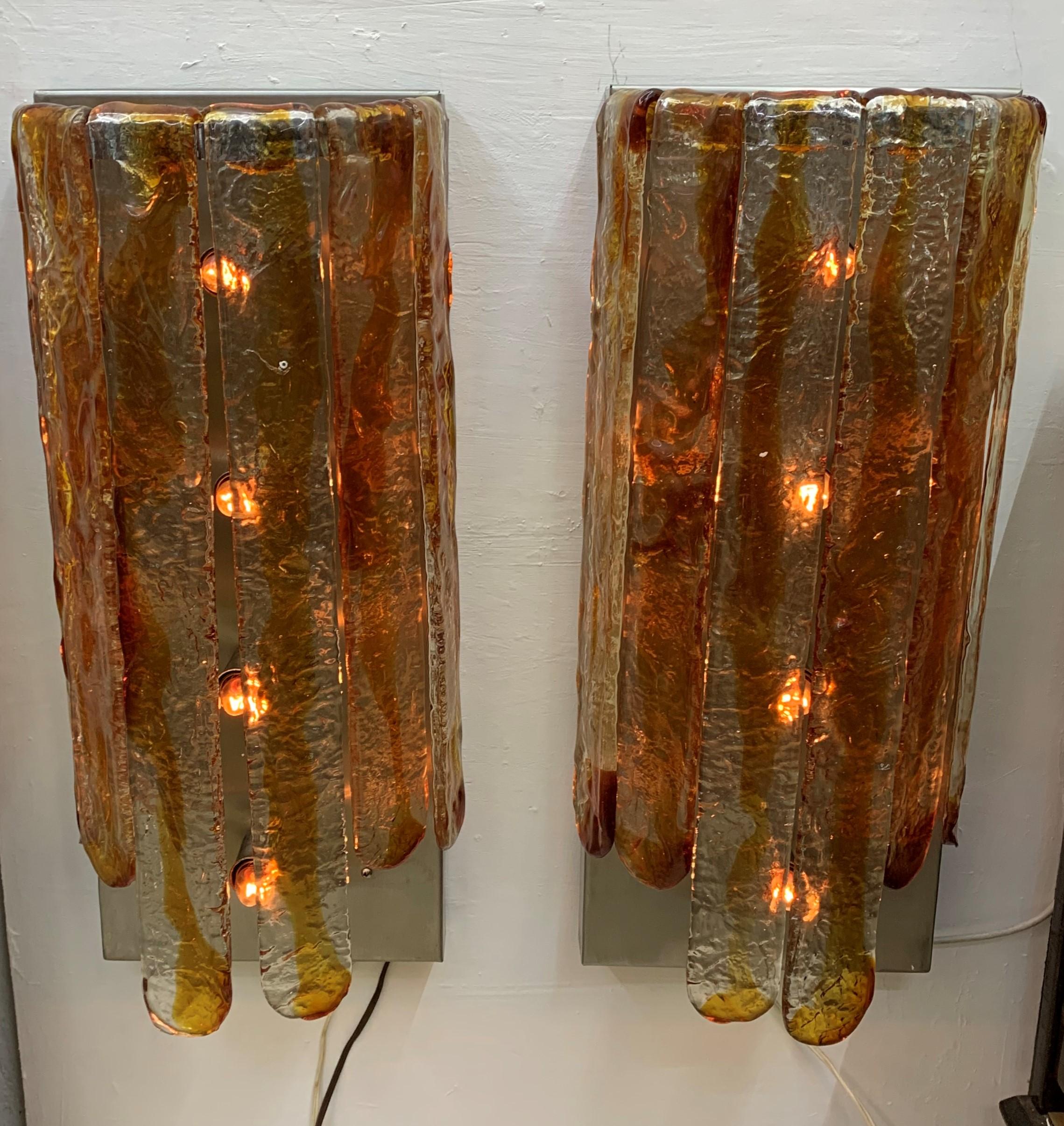 Pair of Mid-Century Modern sconces by Carlo Nason for Mazzega in clear and orange glass, consisting of two sizes of glass blades, and a 4-light stainless steel and wood hardware.
     
