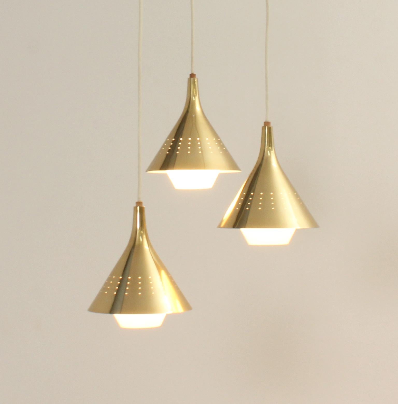 Large cascading chandelier in the style of Paavo Tynell works from 1950's. Stylish perforated fixtures with opal glass, aluminum, brass and teak wood details.