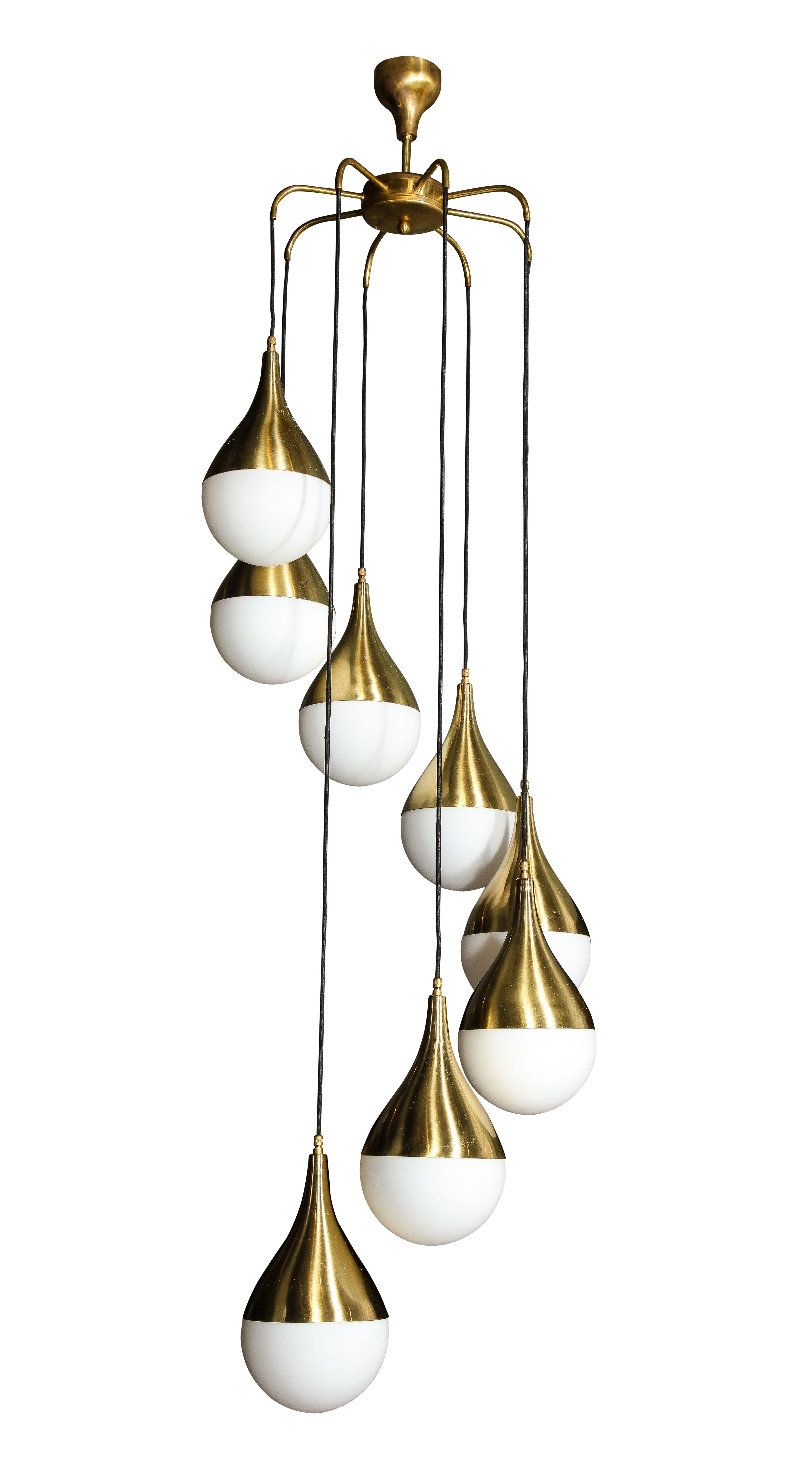 The brass and glass 8-light chandelier suspended from a central brass fixture.
      