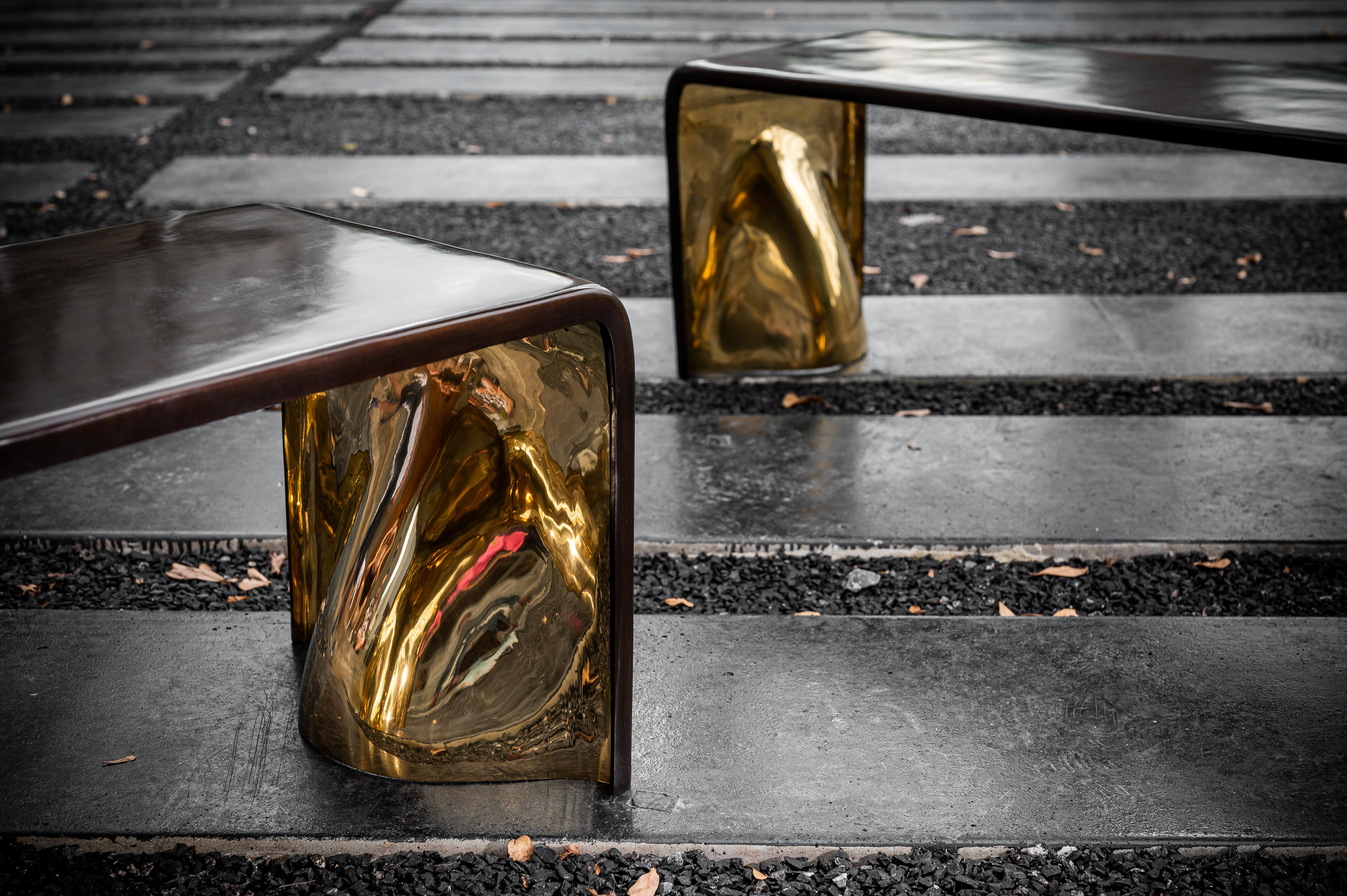 The large Khetan bench is a bronze sculpture inspired by contemporary artists such as Constantin Brancusi and Isamu Noguchi. Cast using the lost wax method, the bench is a museum quality piece shown in dark bronze with a polished gold bronze