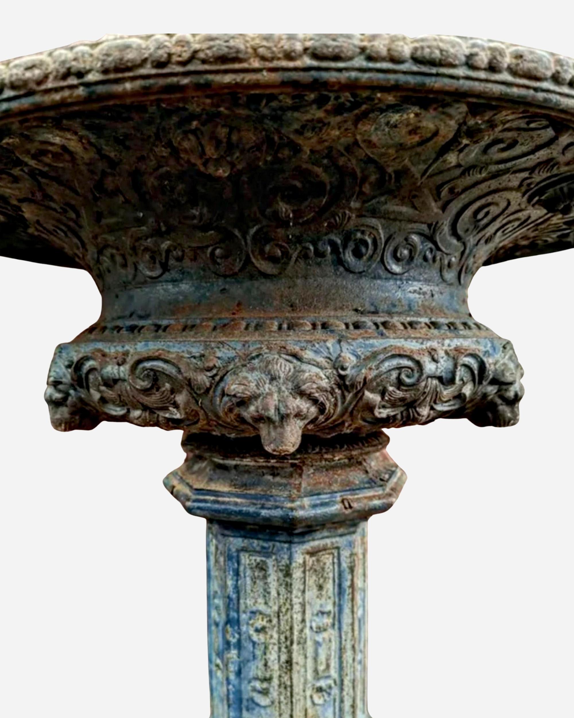 Rare cast iron pedestal basin in neoclassical style, decorated with lion heads, gadroons, and arabesques. With a beautiful original patina.