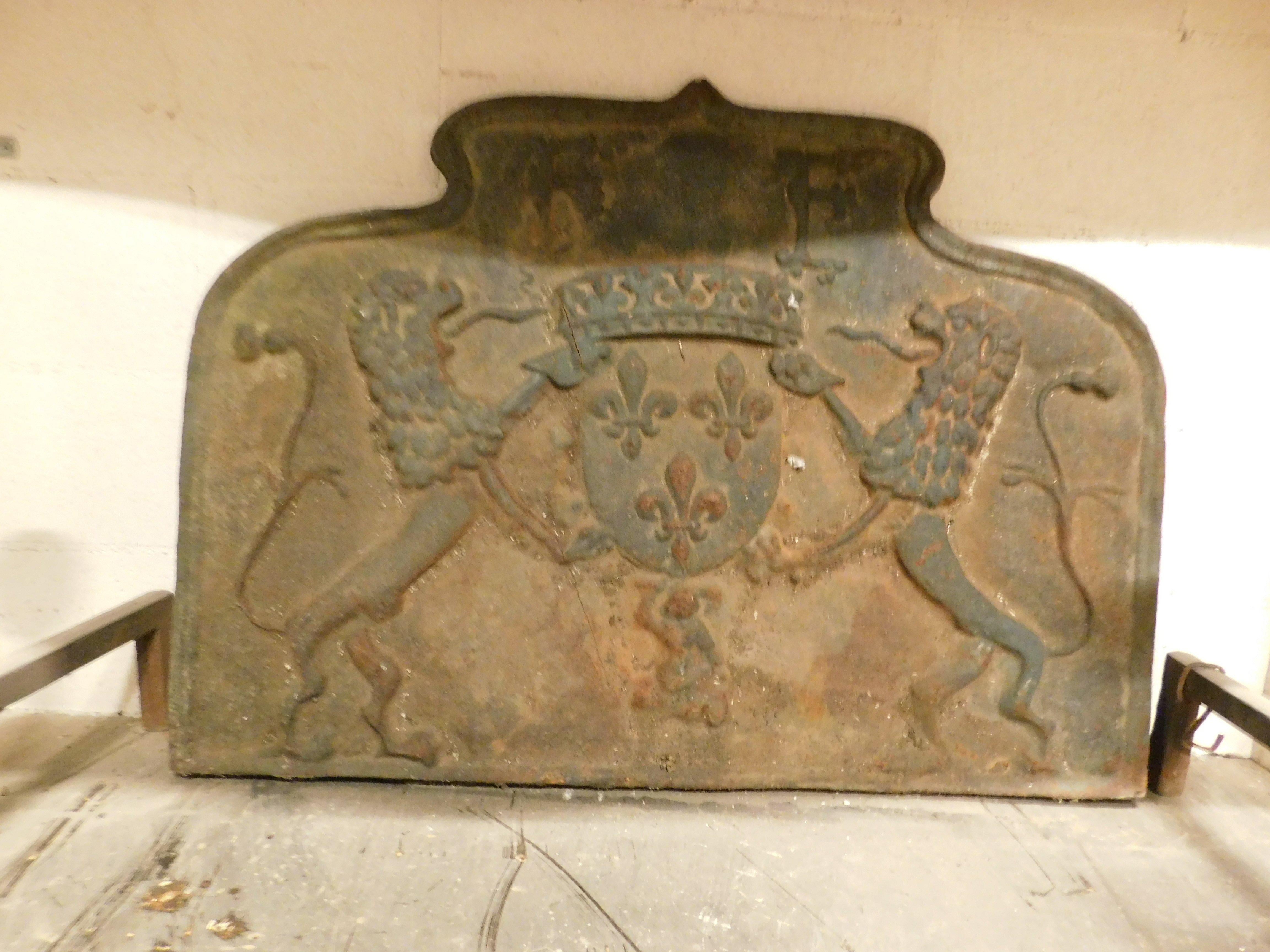 Antique large cast iron fireplace backplate, carved with noble coat of arms, family letters and Florentine lilies, therefore coming from Italy
and built in the 19th century, probably built for an imposing stone fireplace, of large dimensions and