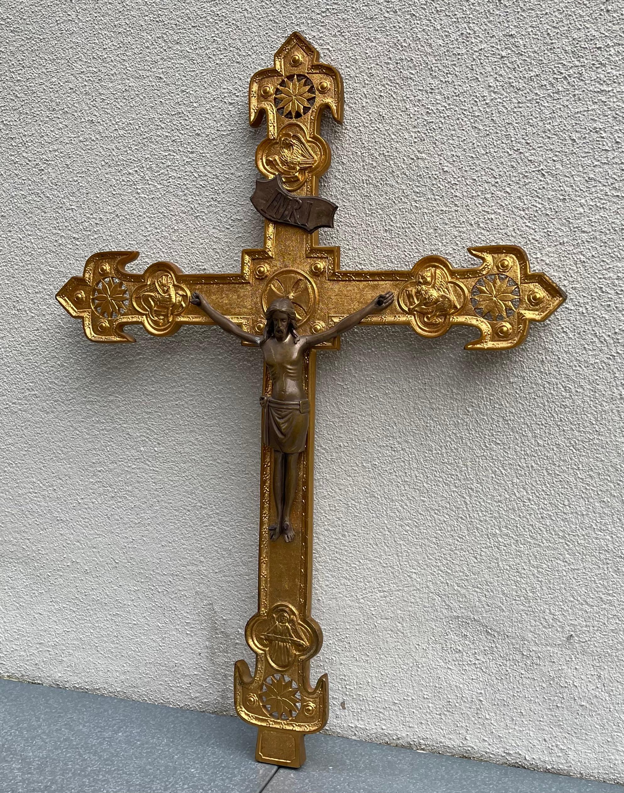 A gilded bronze alloy early 20th century Processional Cross. On the obverse a central Corpus Christi in raw bronze and arms extended wearing a loincloth. Hidden yet partially exposed circular symbol to the left underside of the loincloth. The arms