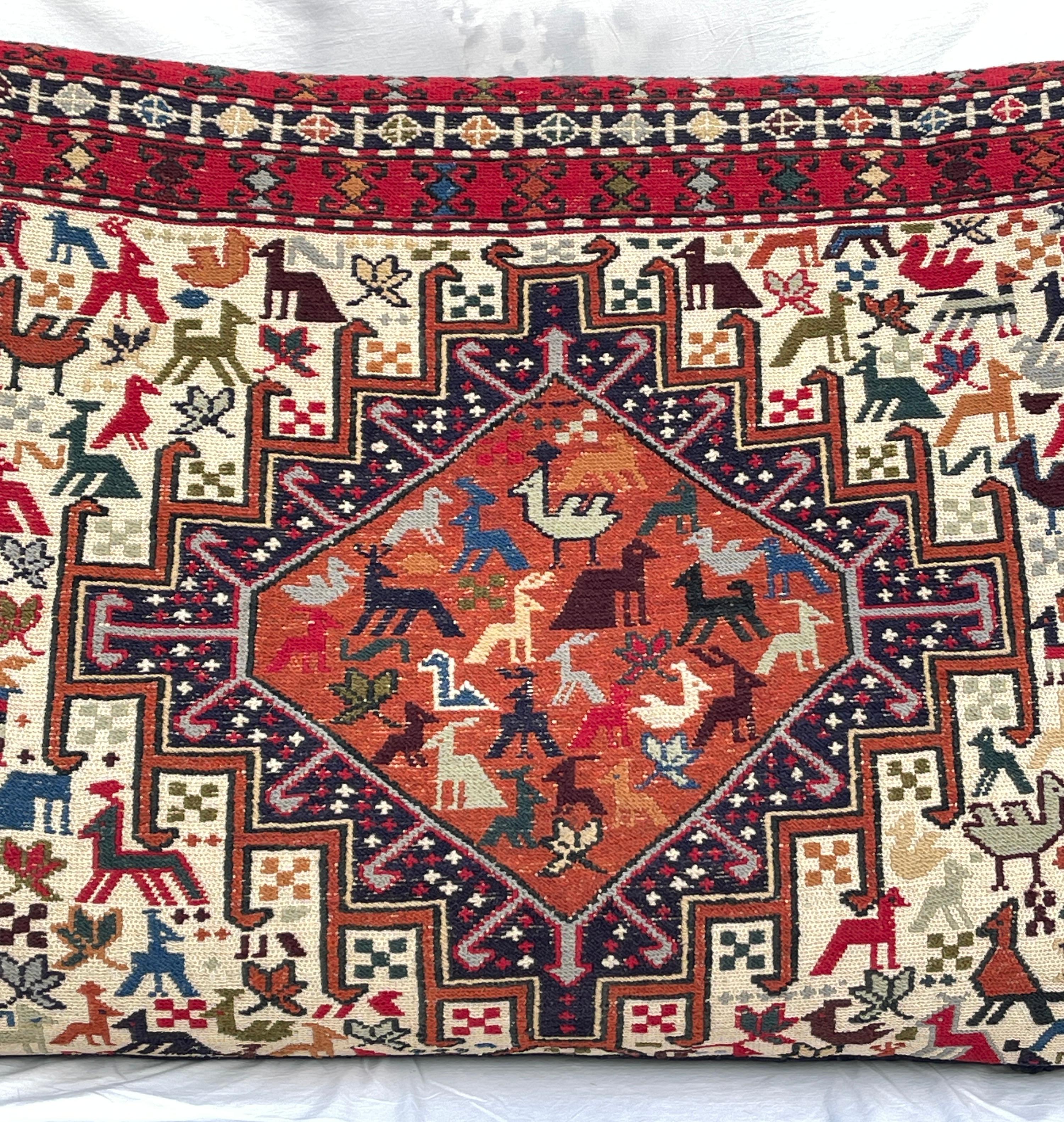 Grande cuscino caucasico in lana Soumak tessuto a mano con motivi animali e motivi geometrici tribali.  Il retro è in tessuto di cotone nero, con una cerniera per rimuovere il contenuto del cuscino e pulire il rivestimento esterno. 
