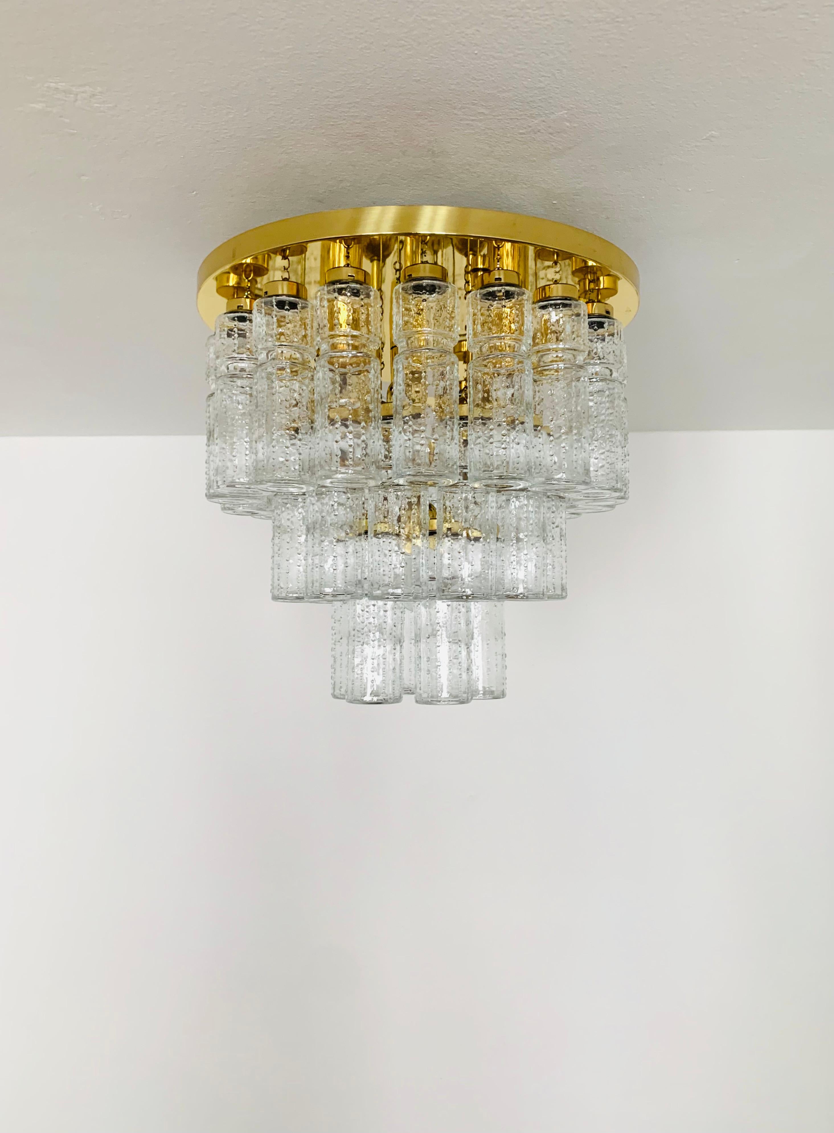 Impressive ice glass ceiling lamp from the Limburg glassworks around 1960.
The lamp spreads a wonderful play of light and is a real eye-catcher.
The 36 glass elements are suspended on 3 levels.
Very elegant design and high-quality