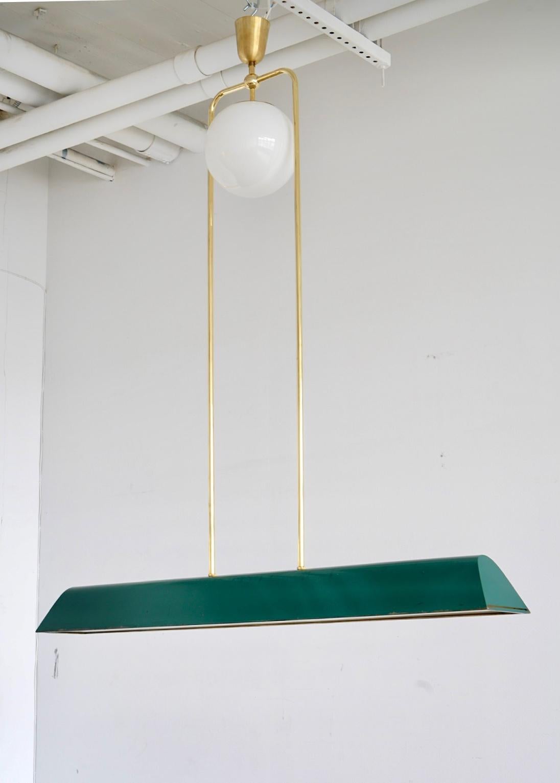 Rara y gran lámpara de techo diseñada por Paavo Tynell para Taito Oy, Modelo 1925. Hacia 1940.
Barra horizontal de metal sobre suspensión de latón y gran pantalla de cristal opalino. Acabado original lacado en verde oscuro.
Cables existentes,