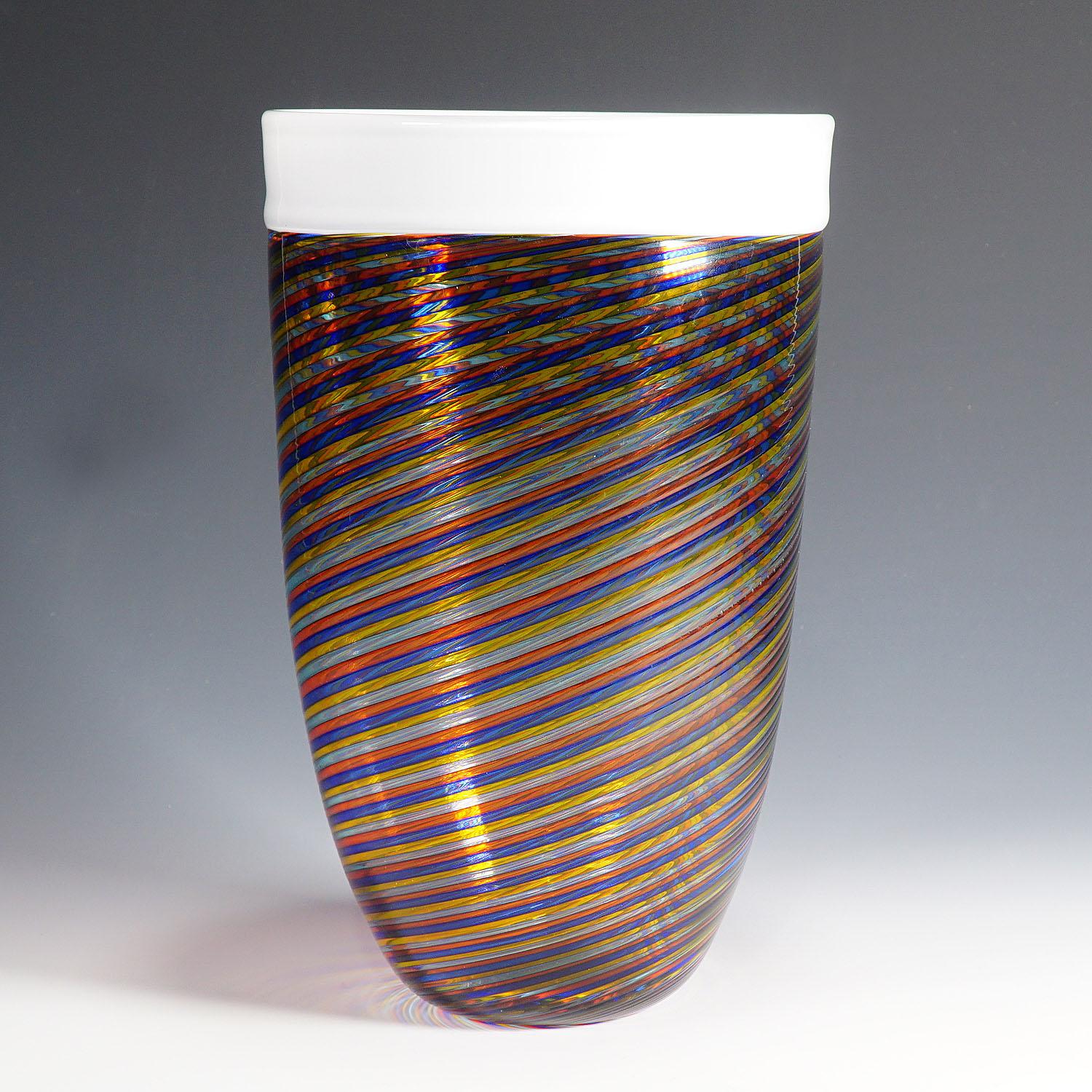 A rare filigrana glass vase manufactured by Vetreria Gino Cenedese ca. 1960. Multicolored filigrana glass bands in red, blue, yellow and light blue and a white rim attached in incalmo technique. A rare and decorative midcentury modern glass