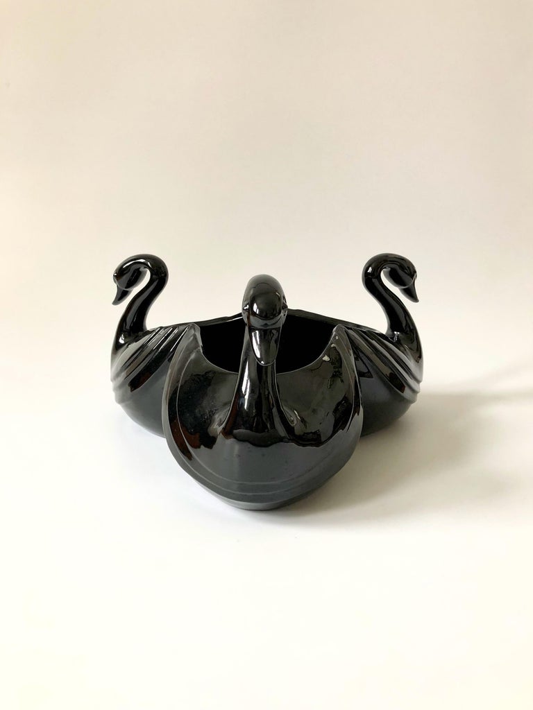 A large vintage ceramic bowl by Fitz and Floyd. Made of ceramic in the shape of 3 beautiful swans, finished in a glossy black glaze. The original sticker is on the base and this piece is dated 1985. A wonderful statement piece that would make a