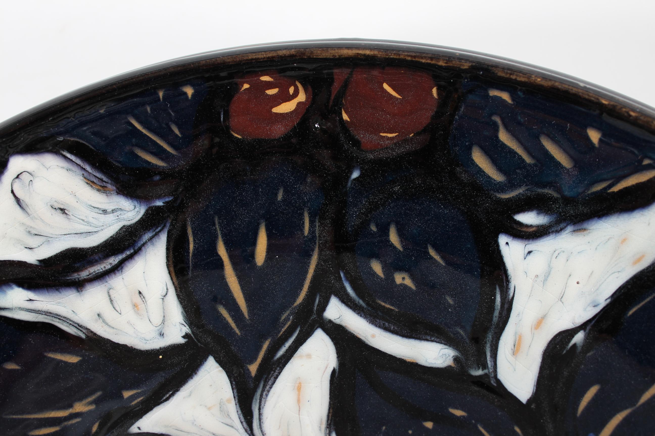 Large ceramic dish by Torben Keramik in Denmark.

The dish is decorated by hand with black, white, brown and ochre cow´s horn glaze in a harmonic pattern of leaves and nuts.
It's in style of Herman A. Kähler in Næstved in Denmark.

Very good