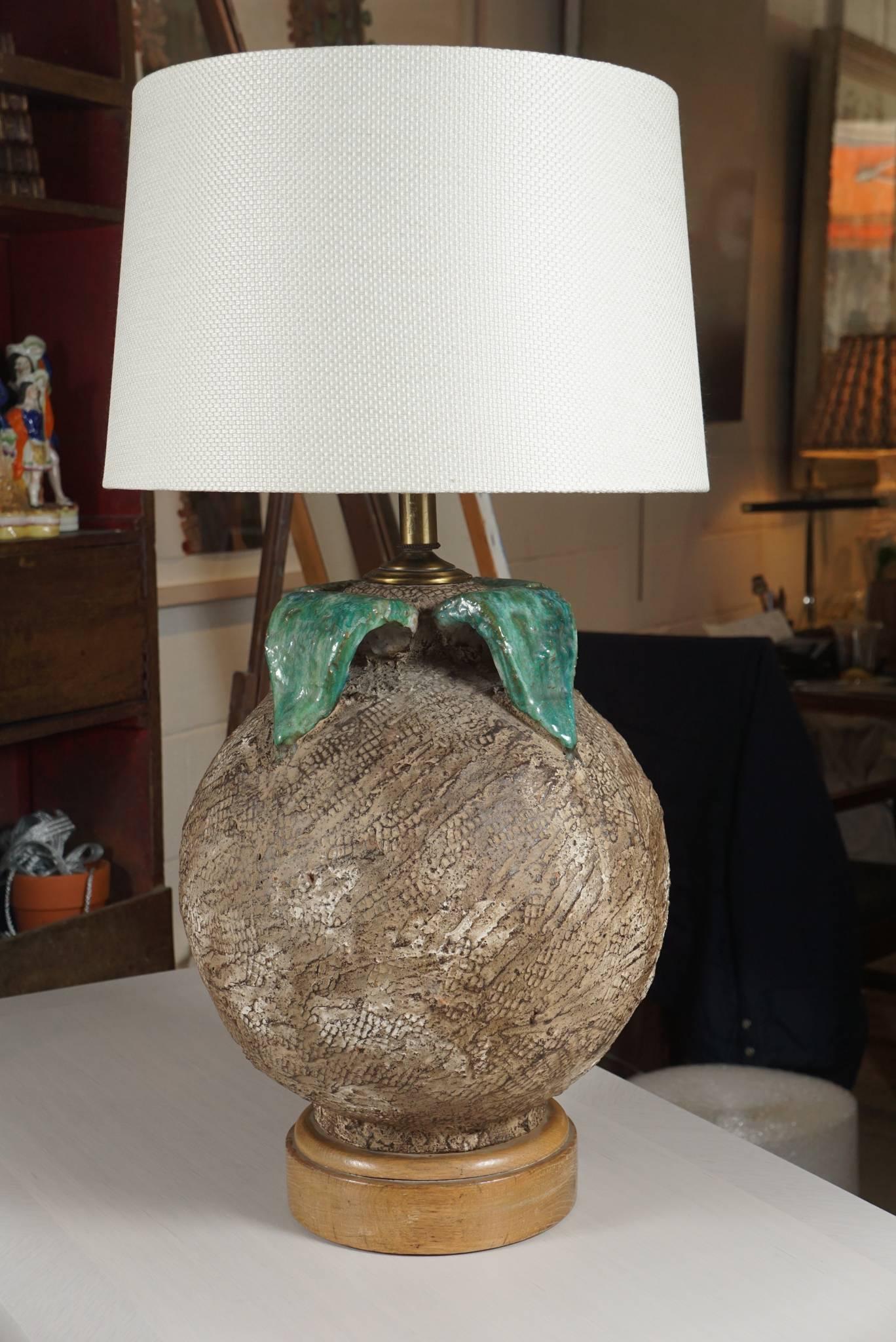 Here is a unique ceramic lamp with a textured surface in the shape of a persimmon.
The leaf top has a high gloss finish n the style of Majolica.
The lamp has been rewired and has new brass double socket and hardware.
The lamp has a great light
