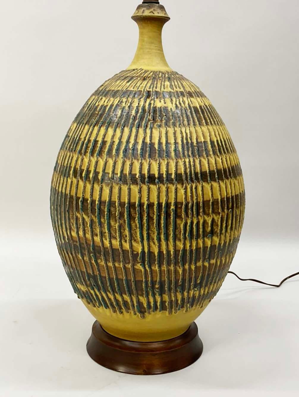 Aquí tienes una lámpara grande y bonita de los años 70. Aunque no está firmada, su forma y escala recuerdan a la iluminación de Bob Kinzie para Affiliated Craftsmen. La lámpara tiene un esmalte inusual en un rico amarillo miel con motivos