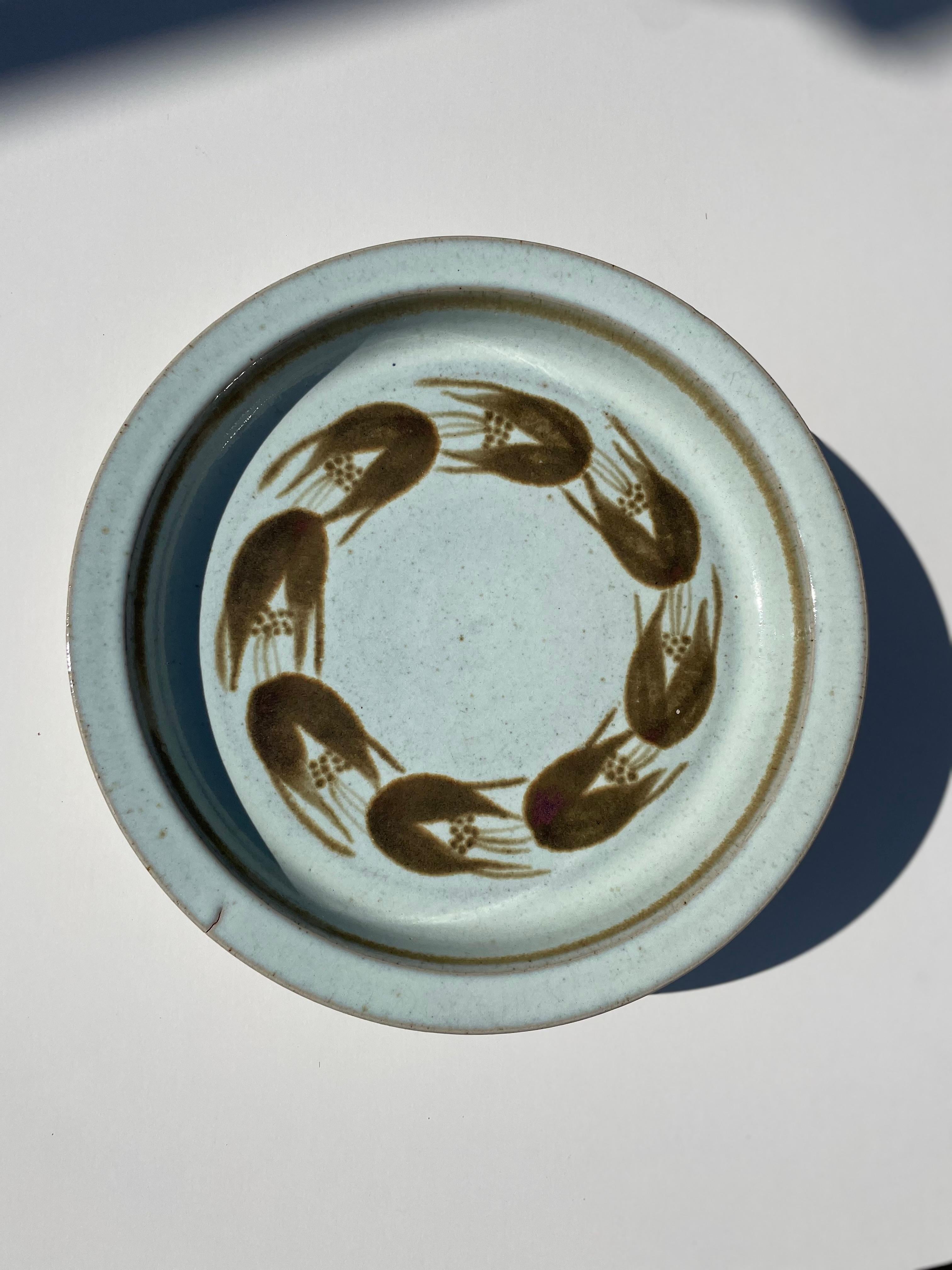Handmade Danish modern round centerpiece with light sky blue glaze and large stylized organic caramel colored decorations in a circle. Manufactured by Eslau in 1987. Signed and dated under base. Small line from production - see photos. Beautiful