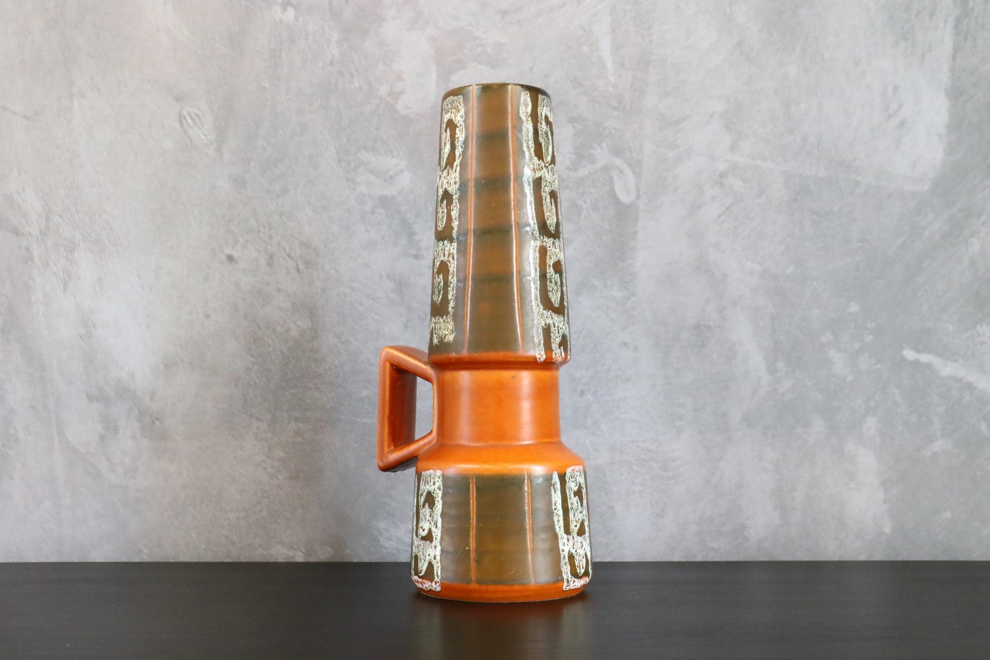 Large Ceramic Mid-Century West Germany vase 274 30cm - Bay Contura - 1970s

This is a large vase with handle teh shape is beautiful and the brown and orange enamel is soft and silky. This piece is characteristic of the West-Germany pottery of the