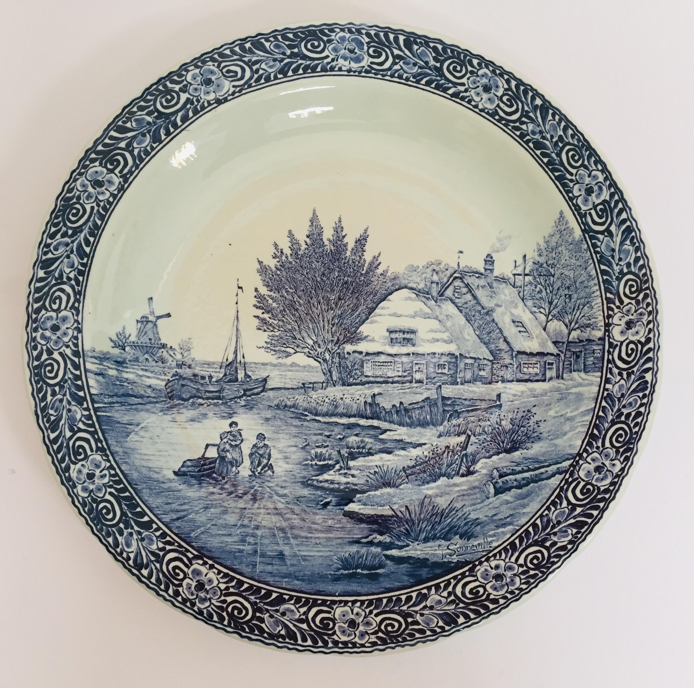 Stunning large Boch Delfts blue and white plate in very good condition.
Beautiful charger that is in perfect condition.
The painting depicts children playing at the edge of a frozen river with a boat breaking ice in the background. It is signed by