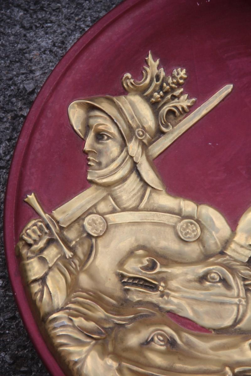 Grande assiette en céramique avec des scènes de guerriers et de chevaux en or 24 carats pourpre attribuée à Finzi.
Décoration gaufrée en or 24 carats.
