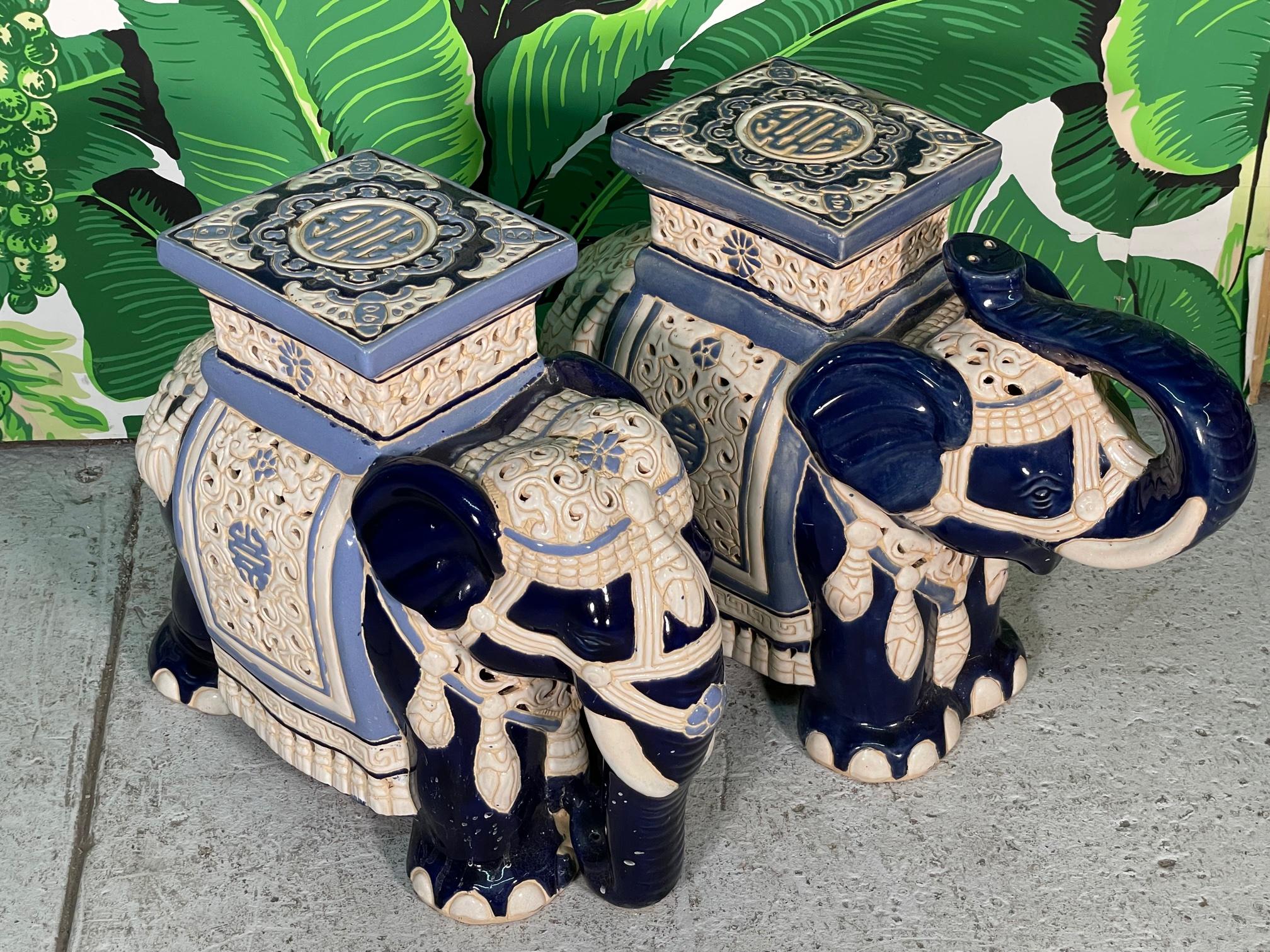 Pair of large ceramic elephant garden stools feature an open reticulated style design and high gloss finish. Beautiful deep blue color highlighted by lighter blues and eggshell coloring. Good condition with only very minor imperfections consistent