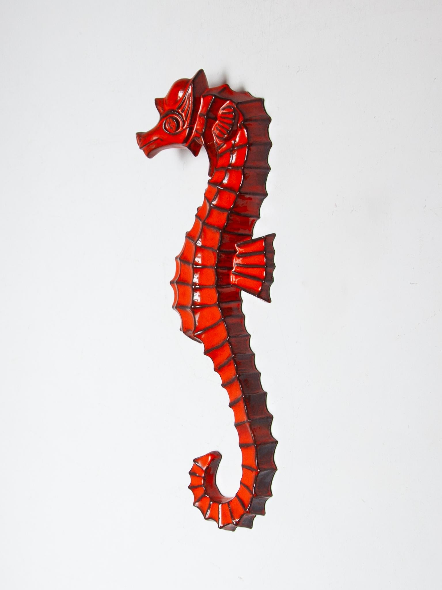 Hippocampe en céramique d'une hauteur de 63 cm Sculpture murale avec une belle glaçure orange fabriquée en Belgique dans les années 1960. L'hippocampe mural est conçu  d'André Bayer, un artiste céramiste belge qui a travaillé dans les années 1960
