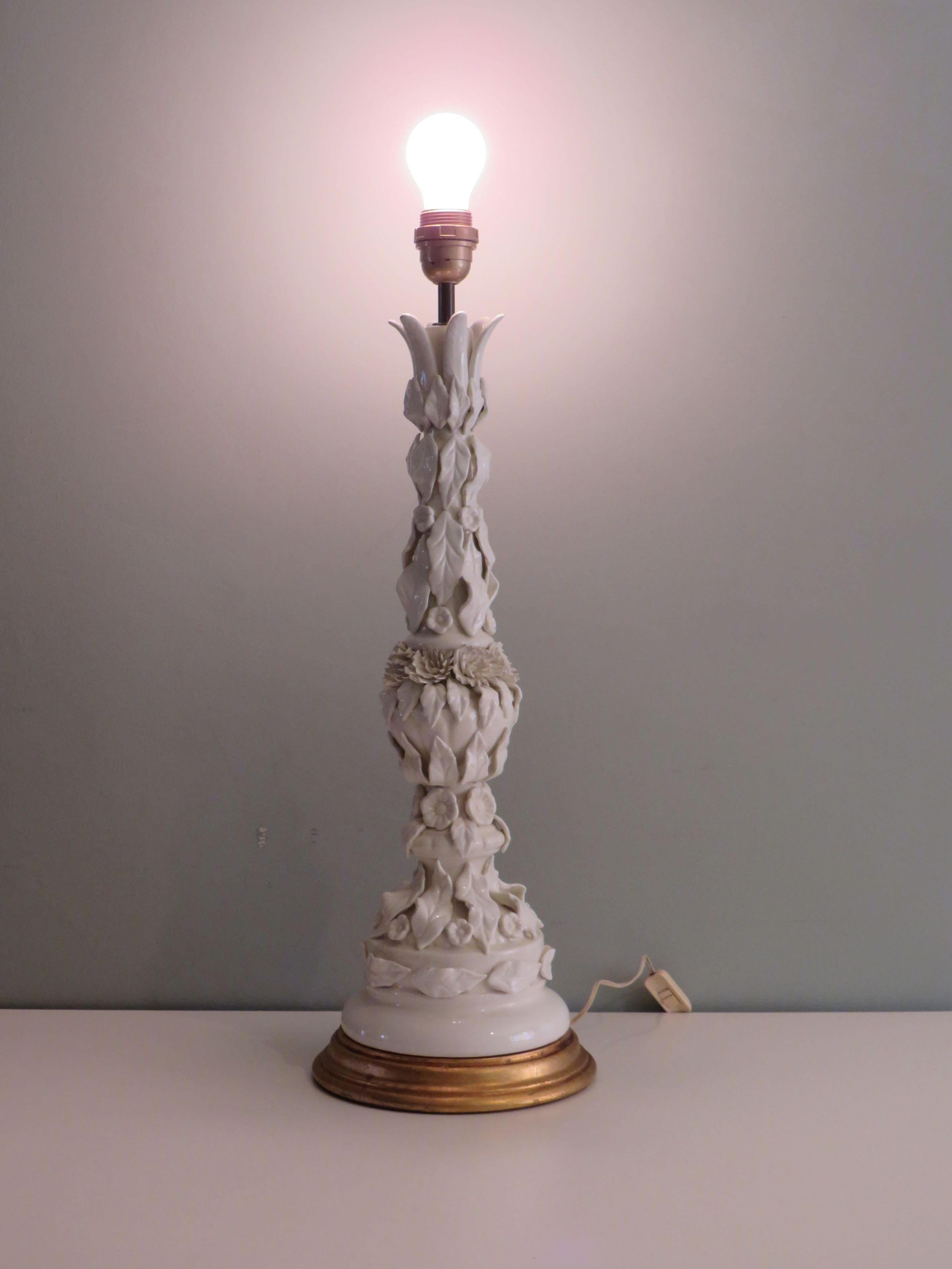 Large table lamp made of white glossy ceramic, lavishly decorated with leaf and floral motifs.
The lamp base is made of gilded wood.
There is an on and off button and 1 E 27 fitting.
Upon delivery to the US, an intermediate plug will be included