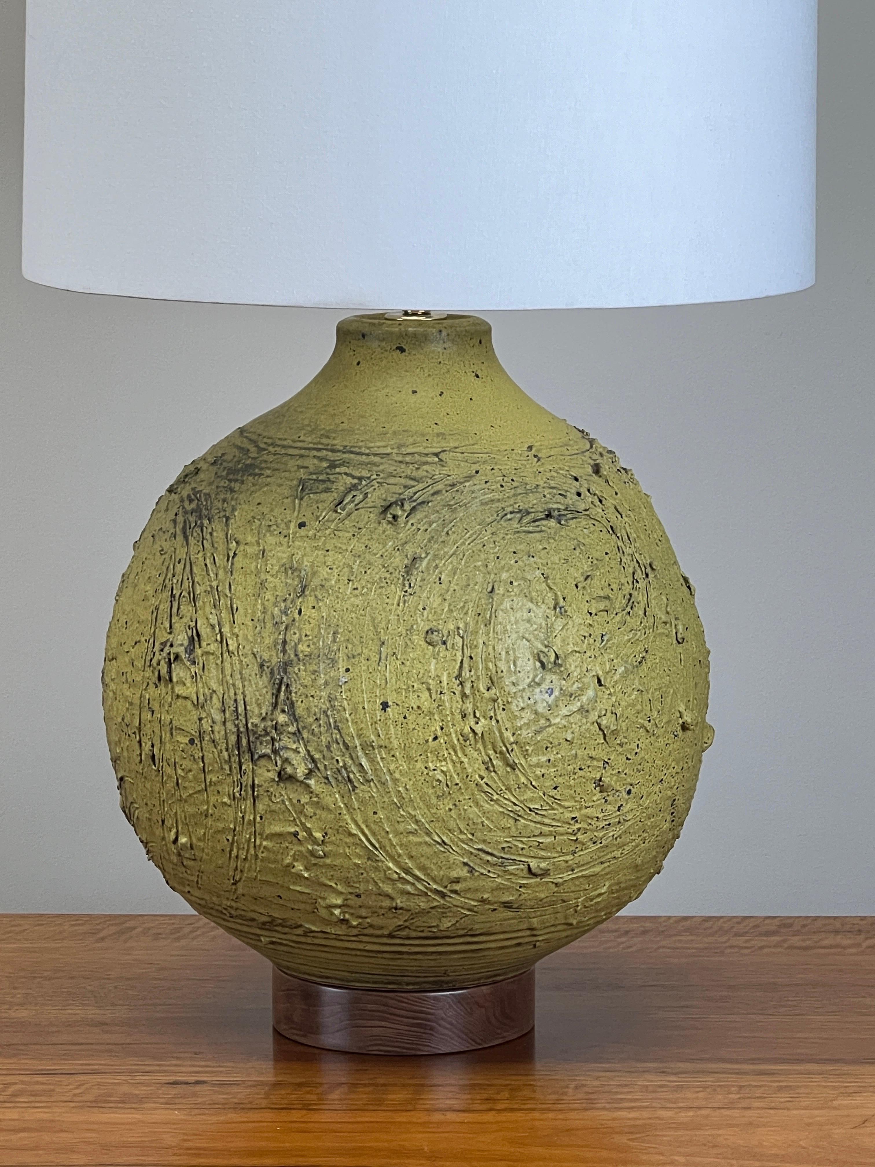 A large scale ceramic table lamp with green glaze and sgraffito texture by Tom McMillin. 