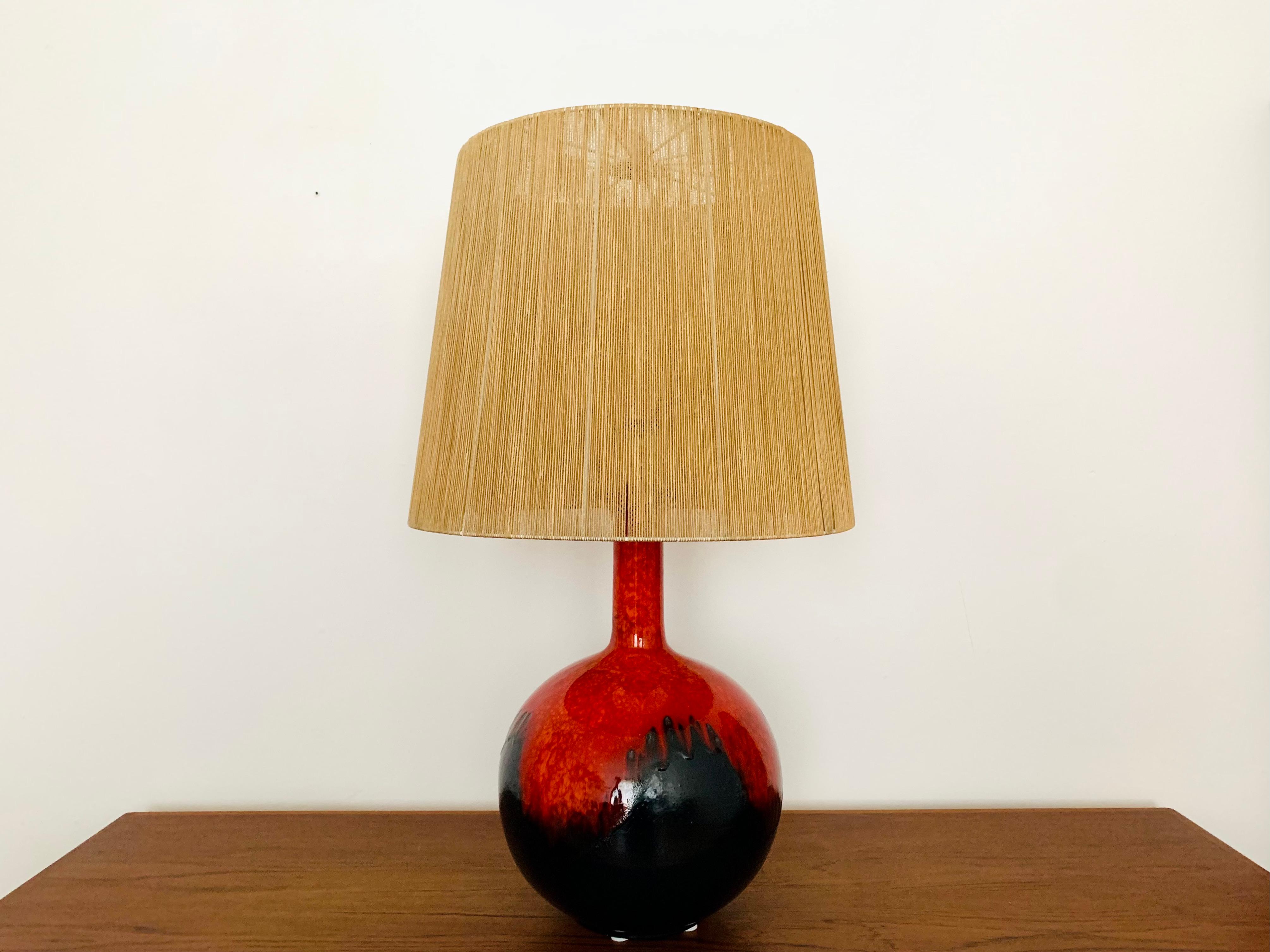 Very nice ceramic table lamp from the 1960s.
Wonderful design and workmanship.
The lamp with the hand-painted glaze is a real eye-catcher.
The raffia lampshade creates a spectacular play of light.

Condition:

Very good vintage condition with slight