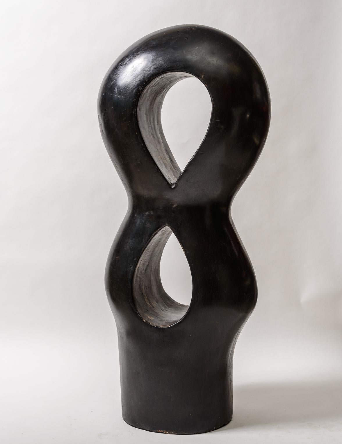 A large ceramic Totem sculpture.
Variegated surface of Black with areas of Tan/Brown showing.
Primitive yet Modern.See photo with the sculpture next to a soda can 
to give you a sense of scale