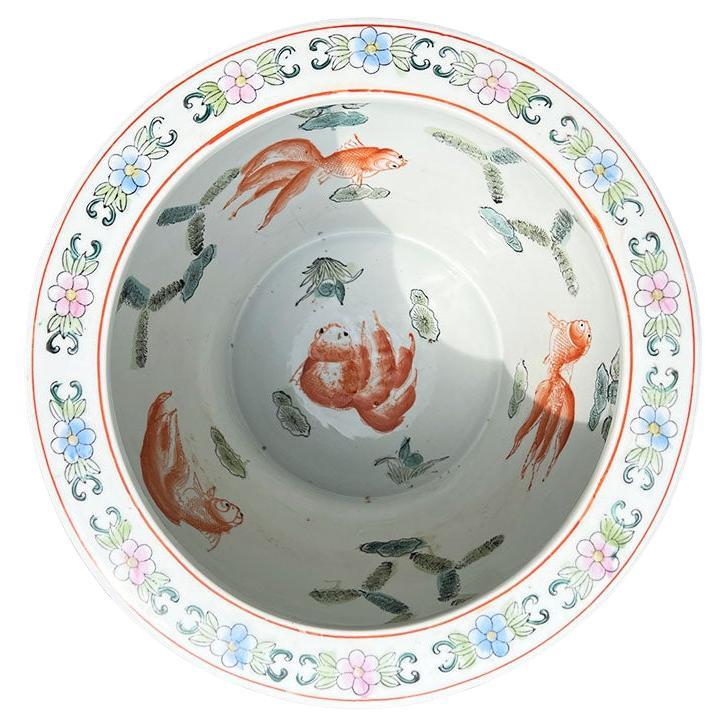 A large ceramic Chinoiserie fish bowl jardiniere or garden planter in turquoise. This timeless beauty will be a fabulous addition to any space both indoor and outdoor. The exterior is hand-painted in a rich turquoise blue with a flower and bird