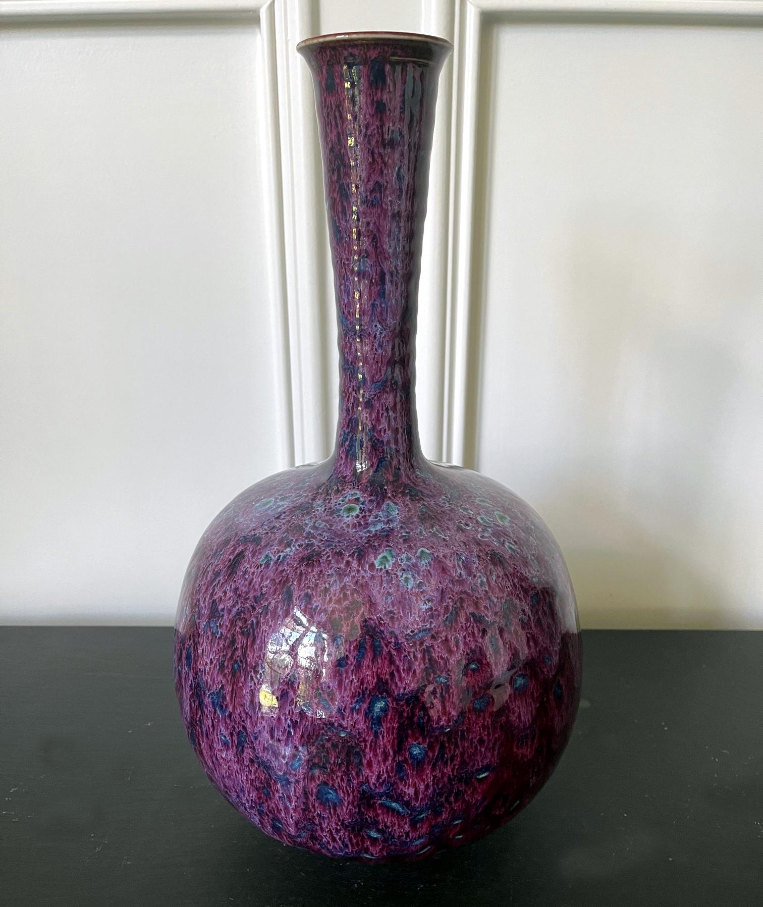 An impressively large ceramic vase with a bulbous body and a long coiled neck by potter Brother Thomas Bezanson (1929-2007). The minimalist modern form might be distilled from the classic Chinese garlic bottle. The high glossy surface displays a