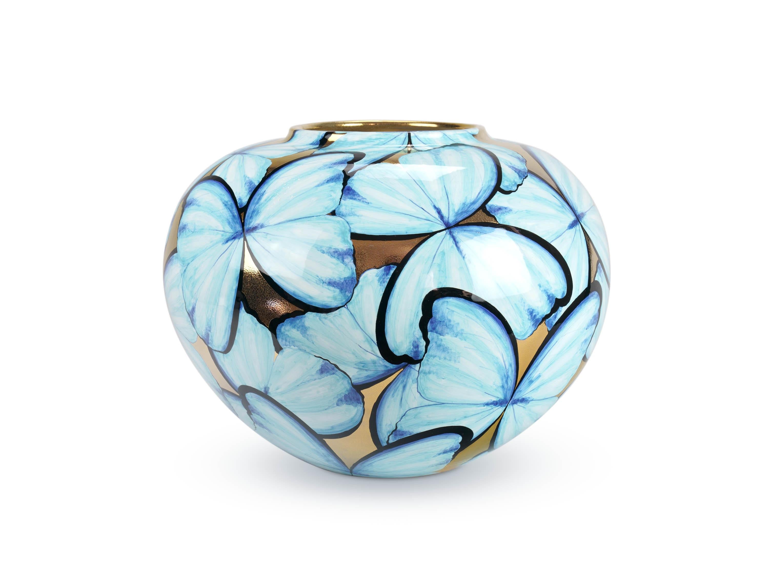 Notre vase en majolique 'Petalouda Gold' met en valeur l'allure intemporelle du papillon bleu en capturant l'essence de son élégance. Reverties dans toutes les cultures comme un symbole de vœux exaucés, de joie et de transformation, la beauté