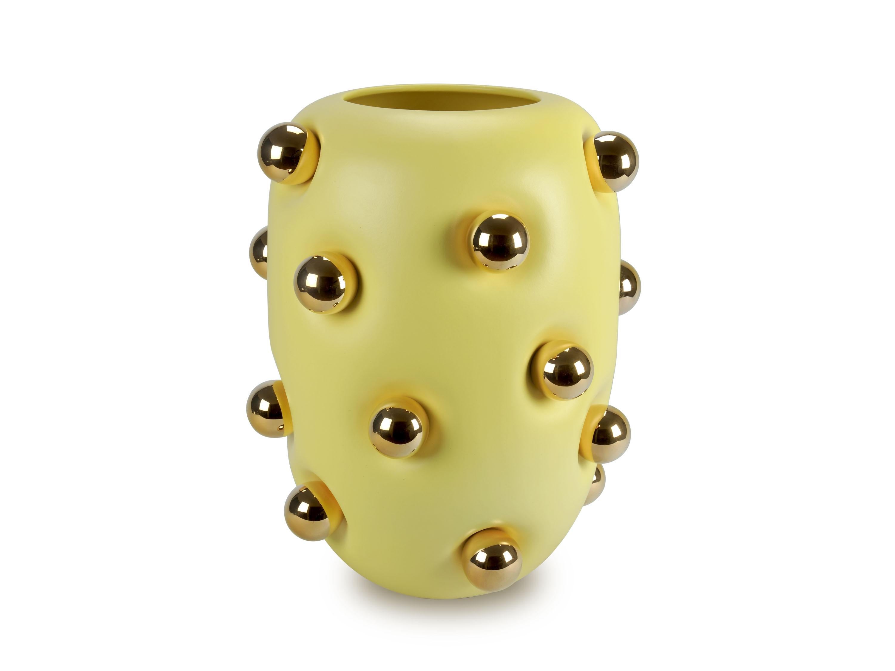 Grande vaso in ceramica giallo pastello, ornato da 19 sfere in ceramica placcate in oro 24 carati. Il corpo del vaso presenta una finitura opaca che esalta la sua forma unica, dando l'impressione che sia fatto di un materiale morbido e flessibile