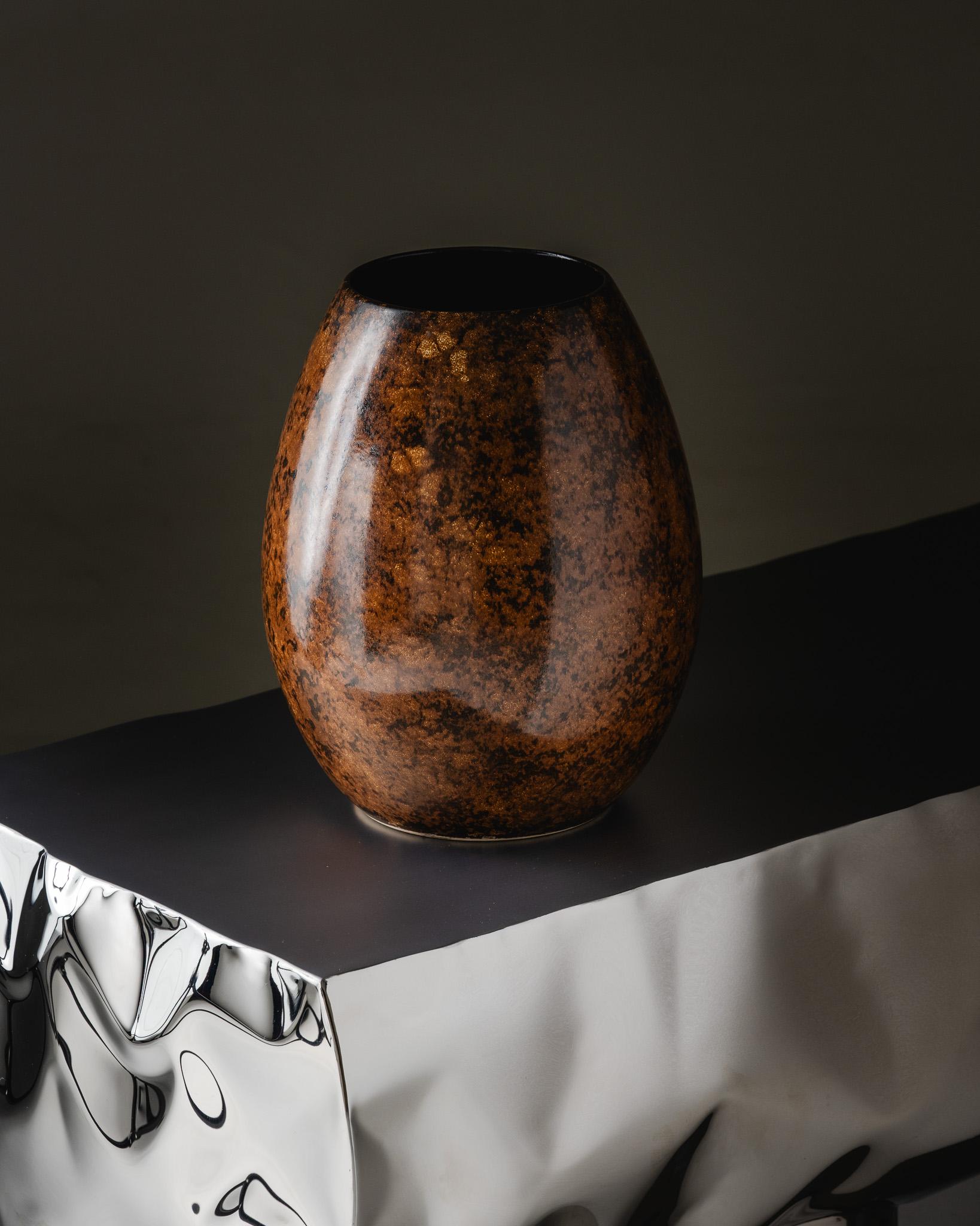 Grand vase en céramique émaillée aux reflets bruns, cuivrés et mouchetés d'or, années 1970, Saint-Clément.
Travail français. Belle forme curviligne avec une surface brillante et texturée typique des finitions Saint-Clément des années 1970. Numérotée