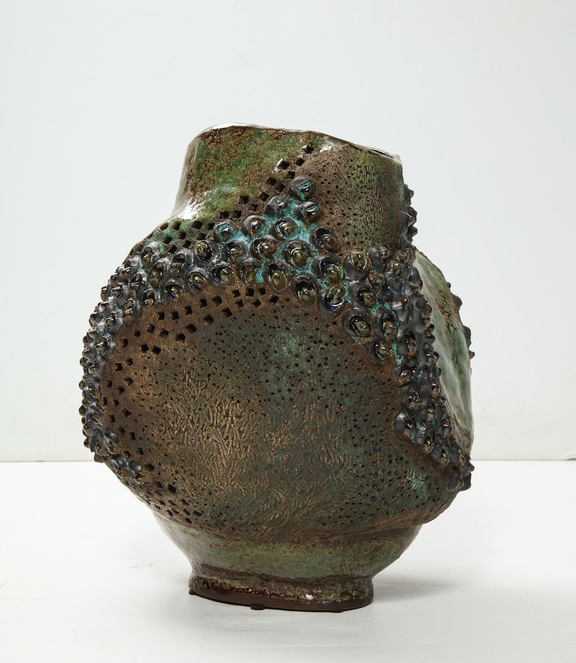 Fantastic hand-built vessel with great texture, irregular form and patterned holes throughout. High-fired glazes in earth tones. Artist signed and dated on underside.