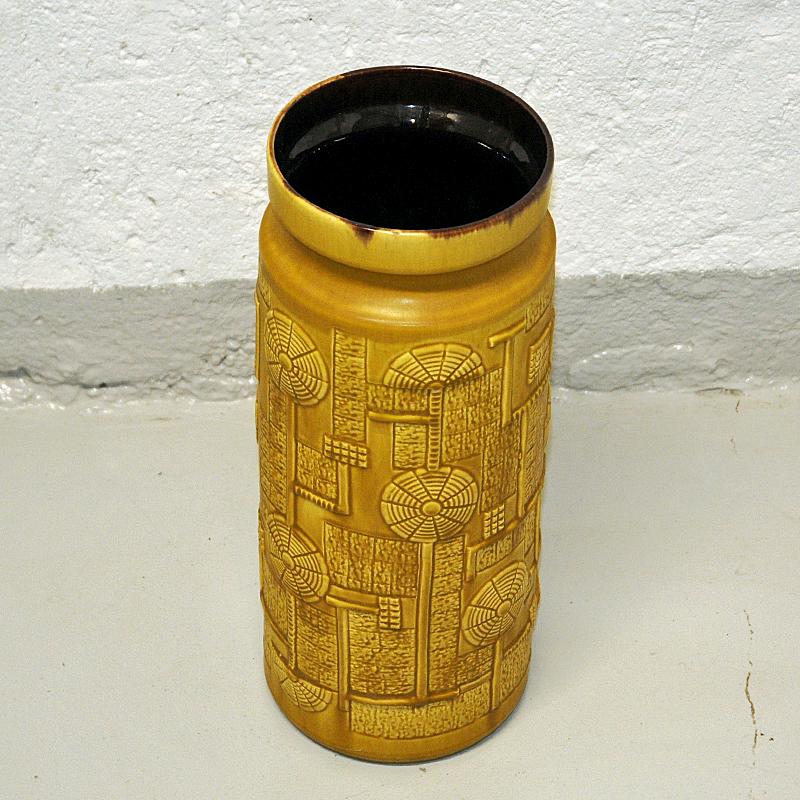 Lovely large vintage Bay vase model Narvik designed by Bodo Mans in West Germany 1970s. This vintage vase made of clay is colored in a beautiful mustard yellow glaze blended with brown and relieffs of geometric patterns called `Narvik` on the