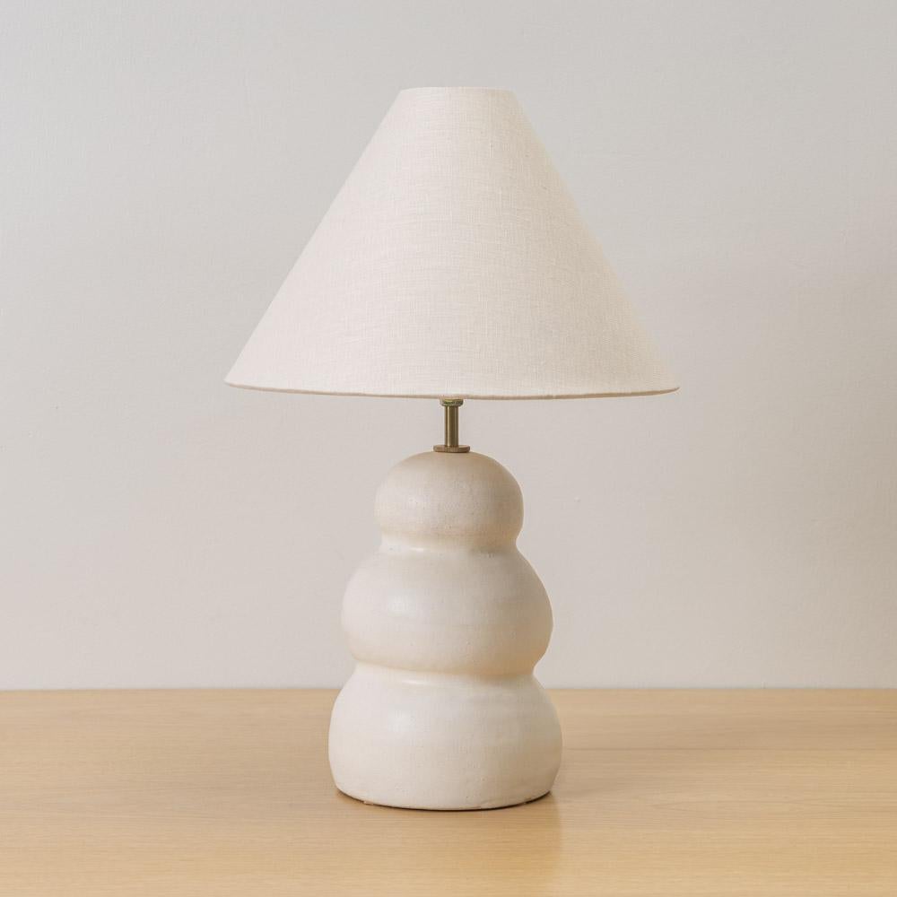 Lampe en céramique faite à la main en forme de colonne ondulée en terre cuite et émail blanc. Nouvel abat-jour en lin, col de tige en laiton et nouveau cordon en tissu blanc avec interrupteur manuel. Fabriqué à la main en Espagne par Marta Bonilla