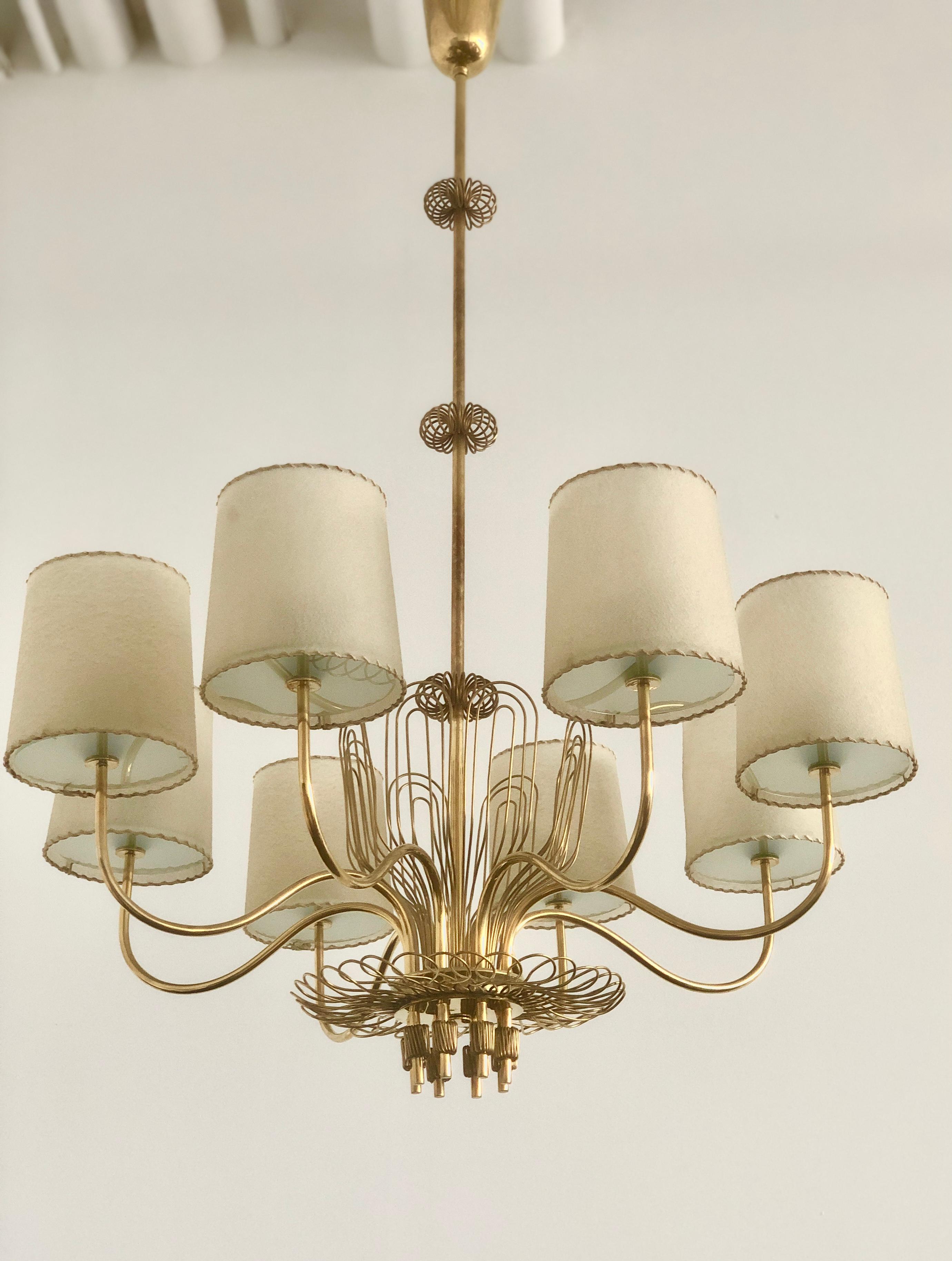 A Chandelier designed by Paavo Tynell (1890-1973) for  Taito Oy.
 Model created circa 1945. Brass frame with rich brass wire decoration and faux parchment shades. The shades later made.
Dimensions : 34