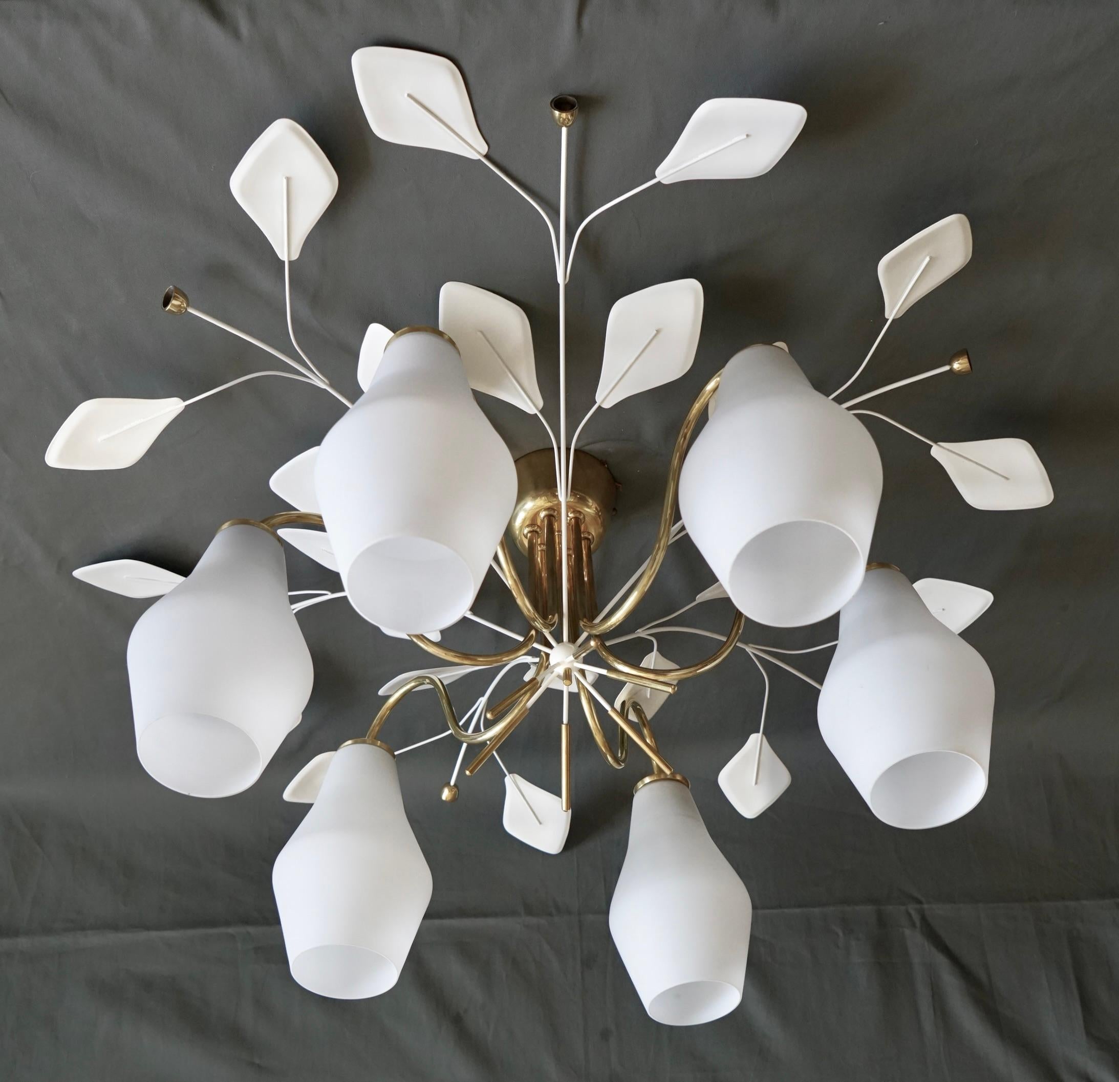 Großer Kronleuchter, entworfen von Paavo Tynell für Idman Oy, Modell K 1-8. 
Finnland, ca. 1950.
Acht Opalglasschirme auf poliertem Messing mit lackierten Messingblättern.
Gestempelt 