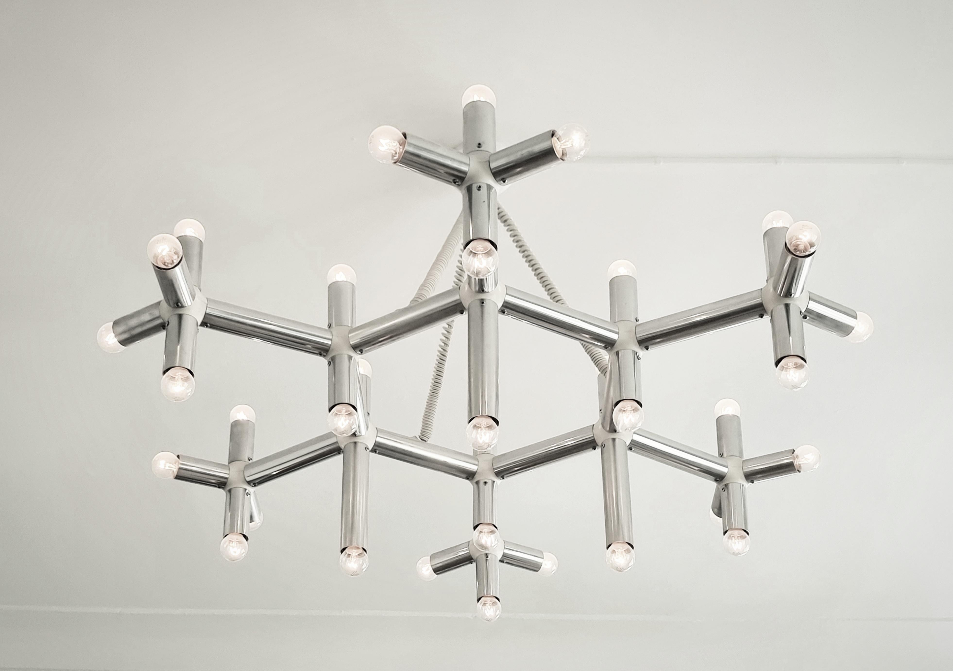 Stylish large chandelier /ceiling lamp, model Atomic. In beautiful condition. Designed by Trix & Robert Haussmann, made for Swiss Lamps, 1960/70s.

Base in aluminium and white plastic. Adjustable height. In good condition, few signs of age and wear.
