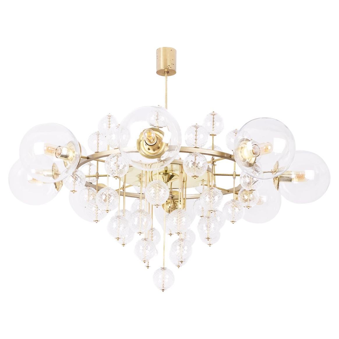 Grande lampadario in ottone dorato e sfere decorative. 1970s. in vendita