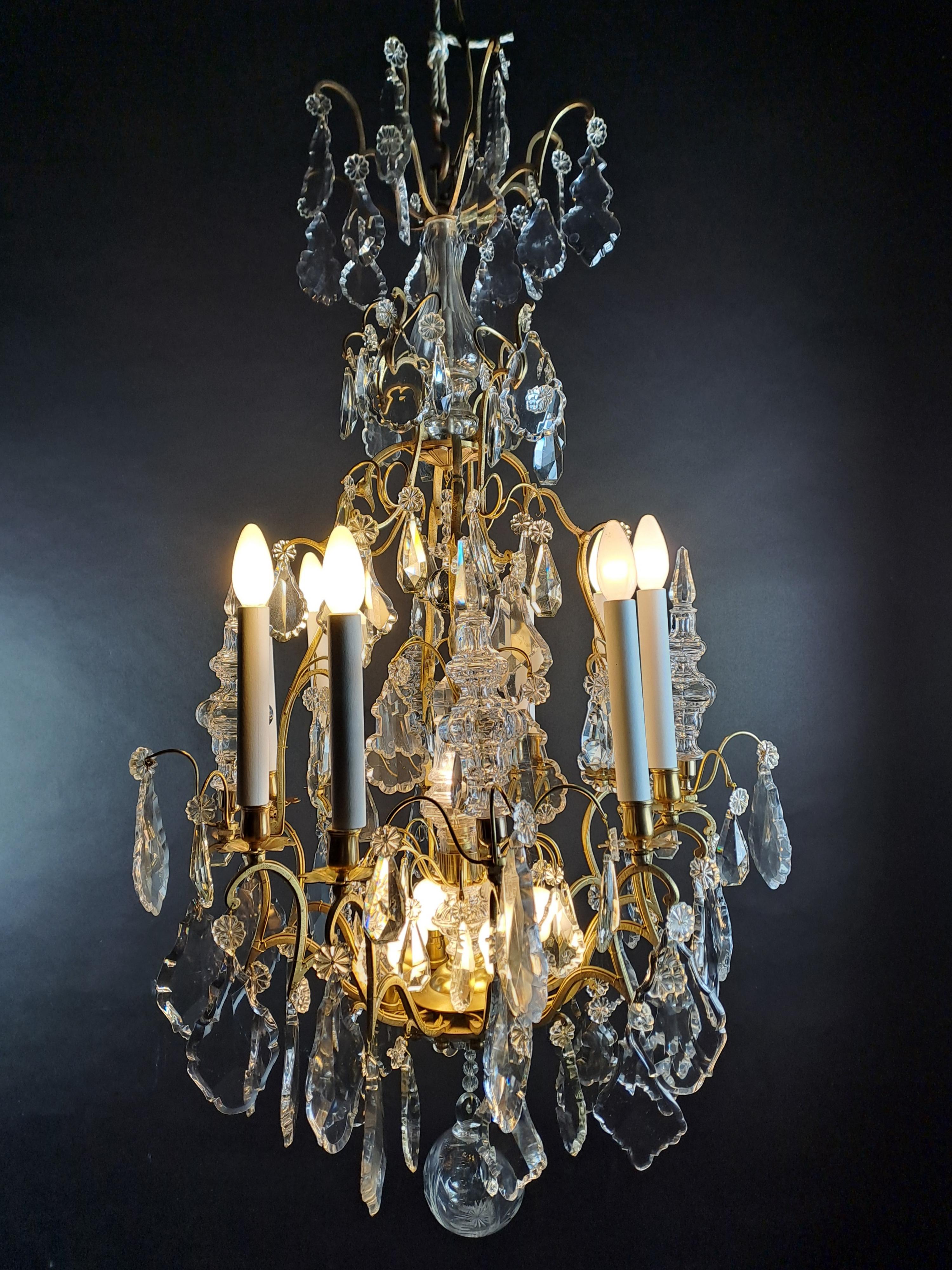 Magnificent large cage-shaped chandelier in gilded bronze presenting a beautiful and generous ornamentation in Baccarat crystal composed of large pendants, daggers (4 daggers in the belt and a large one in the center) and balls.

Baccarat stamp on