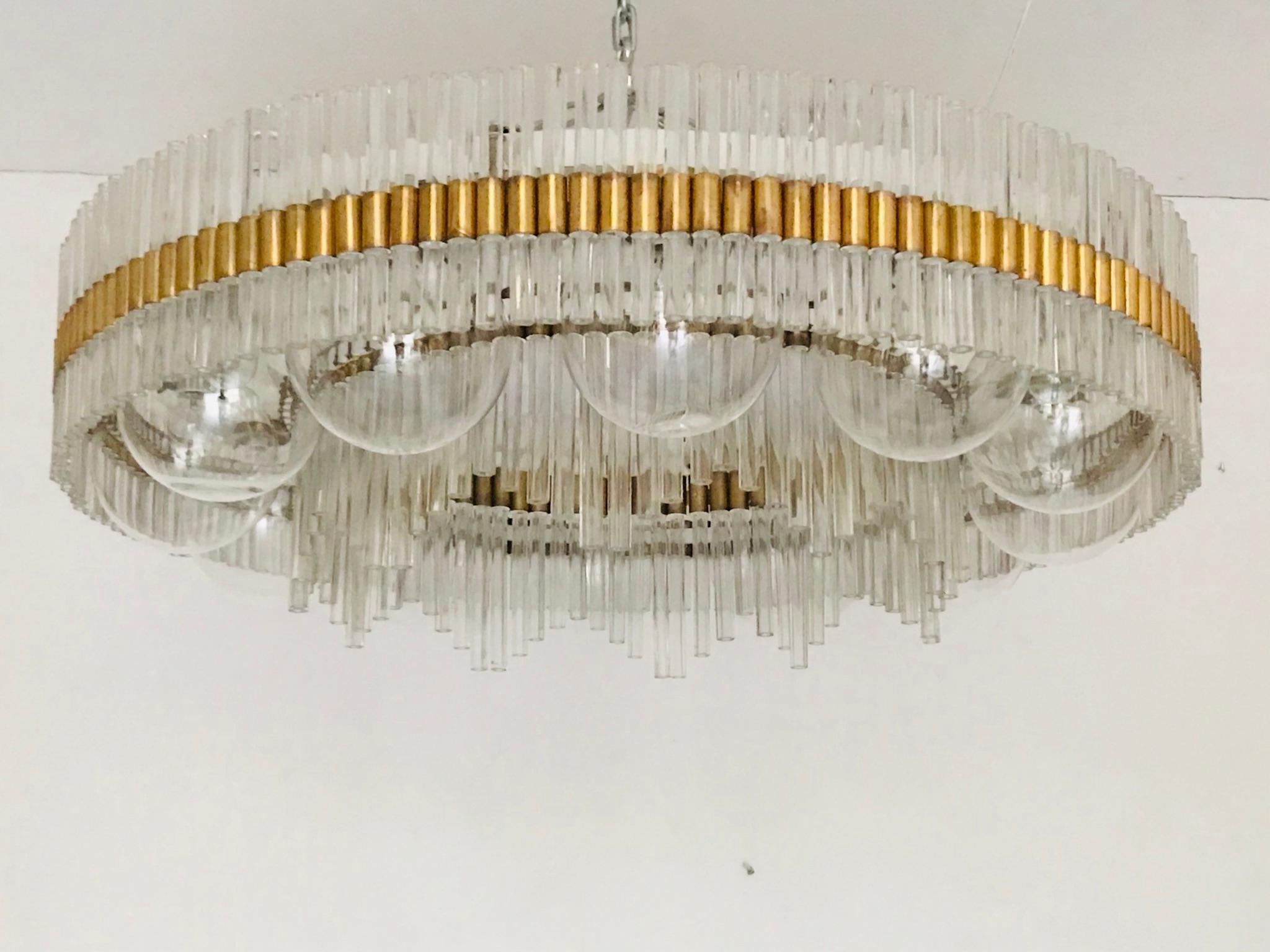 A large chandelier is in a very nice original condition with patina. It is made of glass parts set into the brass. The chandelier has 12 glass bowls - diameter 20 cm. 2 spare bowls including.