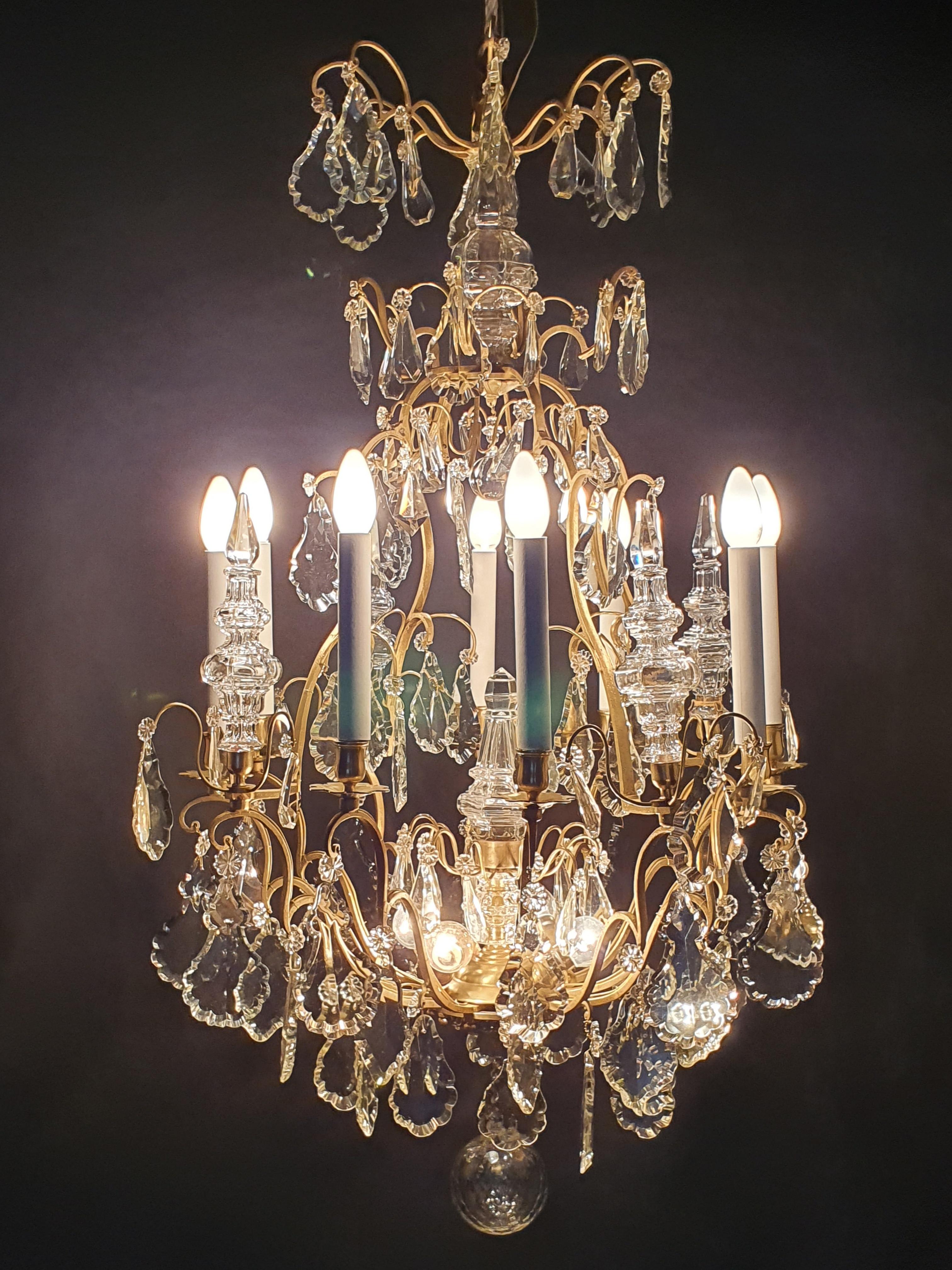 Magnificent large cage-shaped chandelier in gilded bronze with a very rich ornamentation of pendants, large pendants and crystal daggers (4 daggers in the belt). In the Louis XV style Illuminated by 12 lights: 8 around the belt and 4 in the