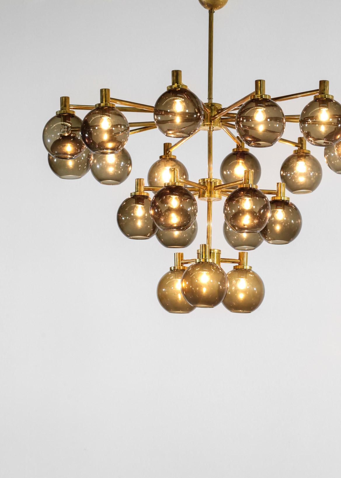 Amazing chandelier in the style of Swedish designer Hans Agne Jakosson or Italian designer Gaetano Sciolari. It is made in brass with 21 smog glass (the three glass on the bottom are less smoked). It is a modern chandelier made by our craftsman