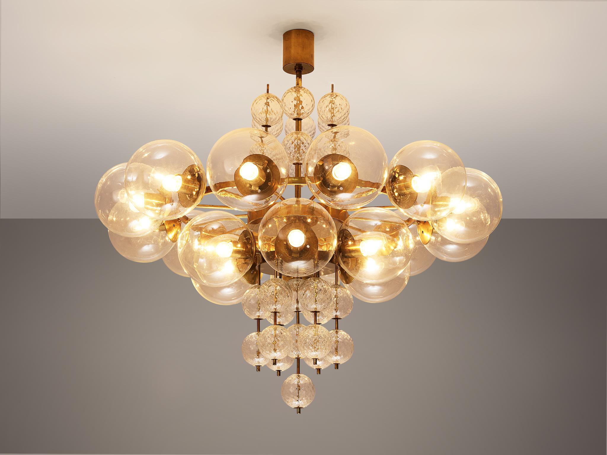 Chandelier, glass and brass, Czech Republic, 1960s

Large chandelier with a combination of big glass spheres which are hanged in two horizontal rows. The smaller glass spheres are made out of structured glass and hanged vertical. The chandelier is