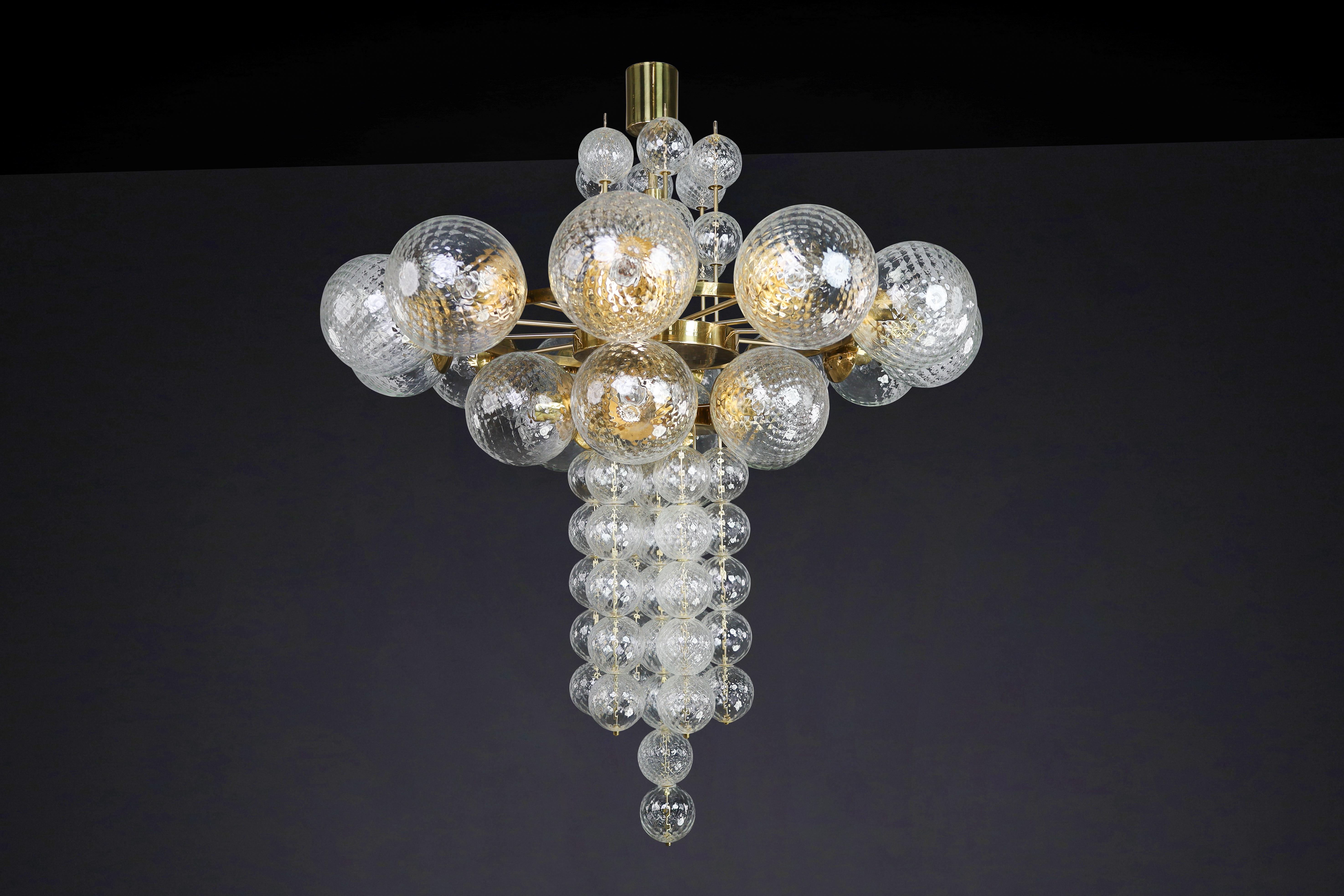 Large Chandelier with brass fixture and hand-blowed glass globes by Preciosa, Czechia, 1960s

This Chandelier was made in the 1960s and is from a grand hotel in Prague. It features a brass fixture and hand-blown glass globes created by the famous