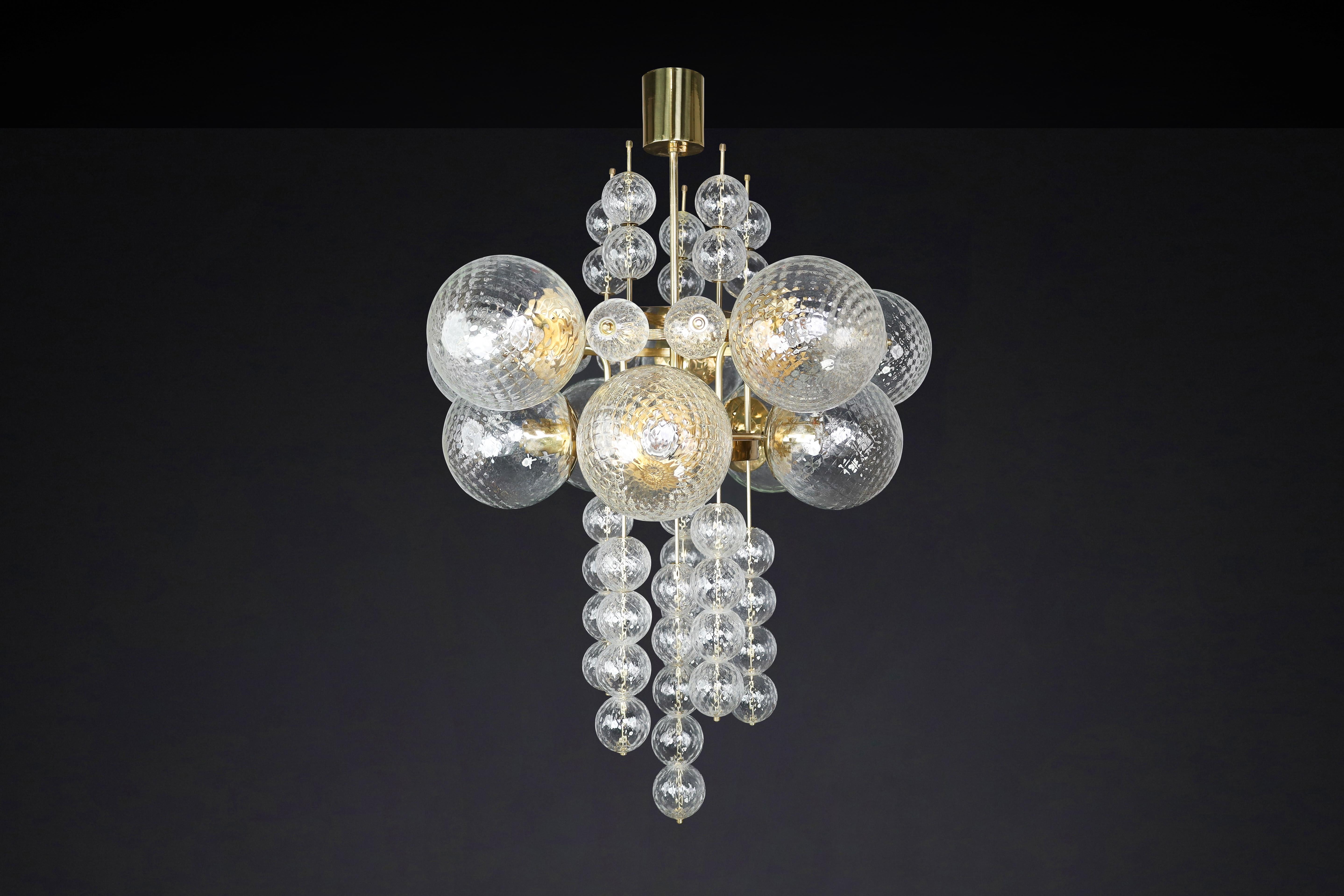 Large Chandelier with brass fixture and hand-blowed glass globes by Preciosa, Czechia, 1960s

This Chandelier was made in the 1960s and is from a grand hotel in Prague. It features a brass fixture and hand-blown glass globes created by the famous